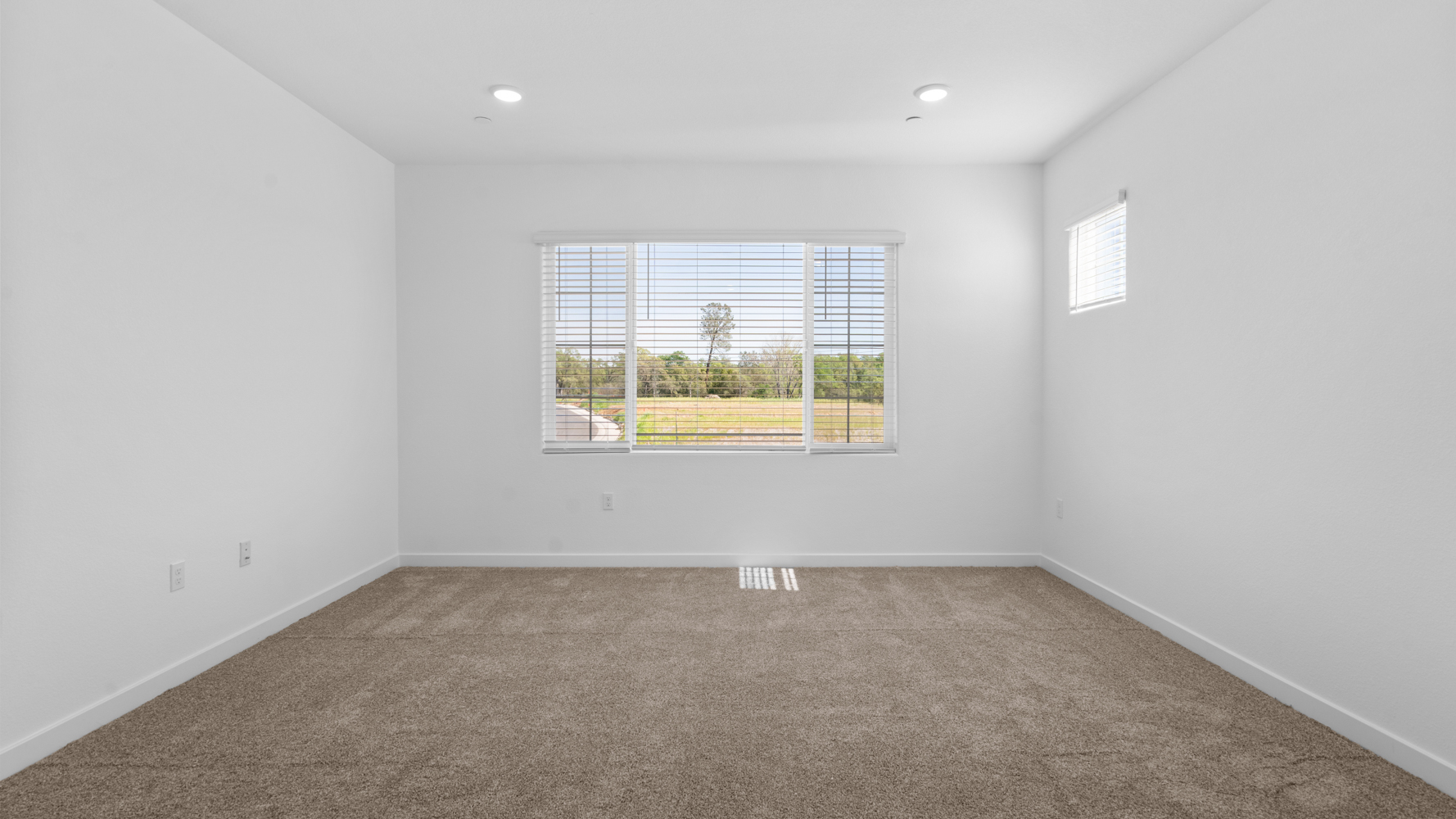 A room with a window and a rug in it.