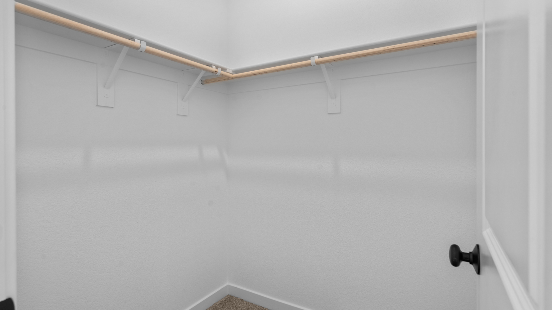 A white wall with a metal bar.