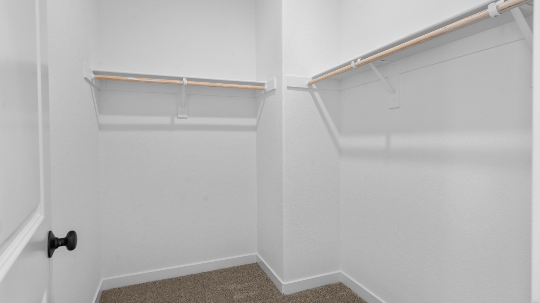 A white wall with a metal bar.