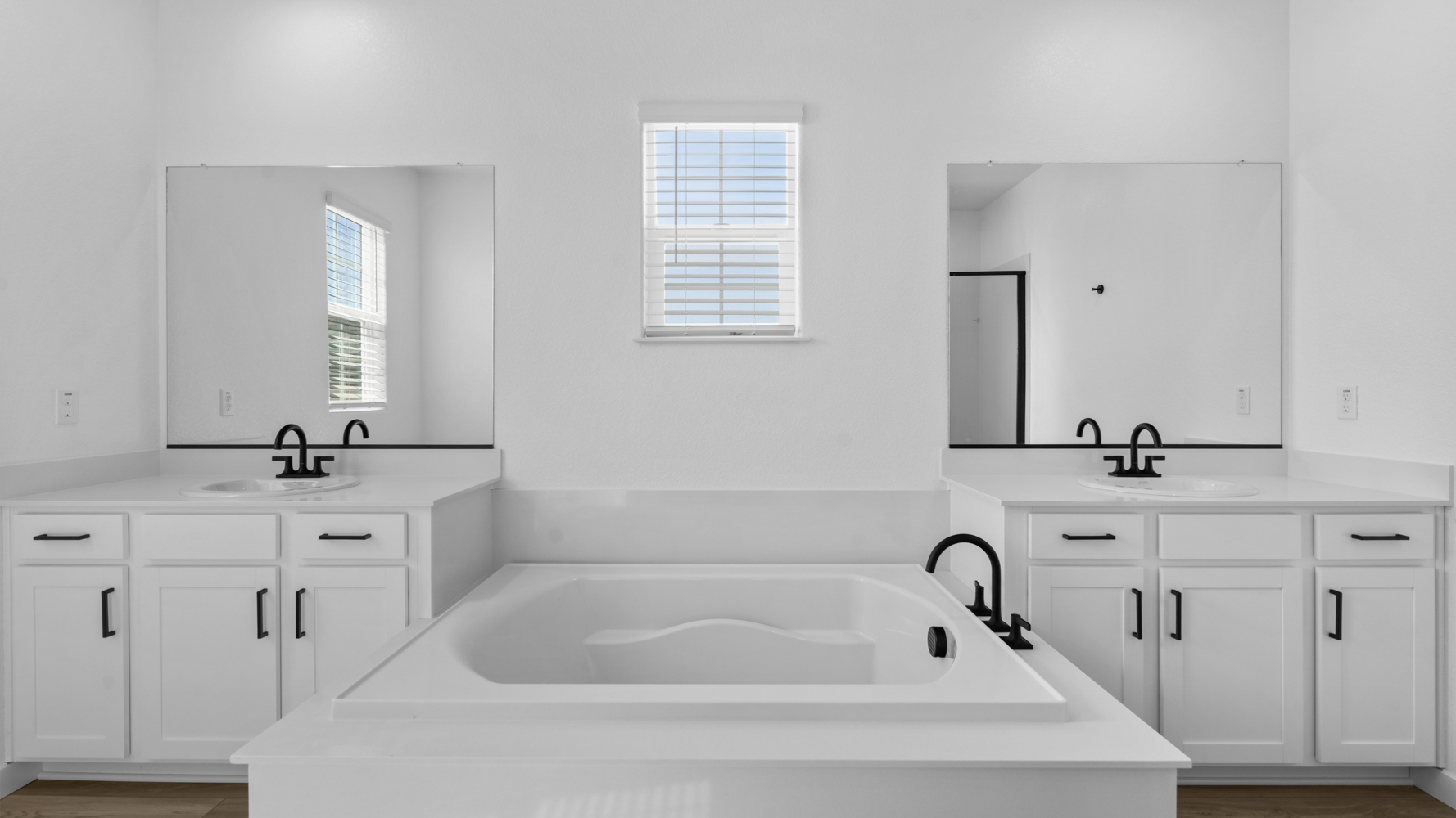 A bathroom with white cabinets.