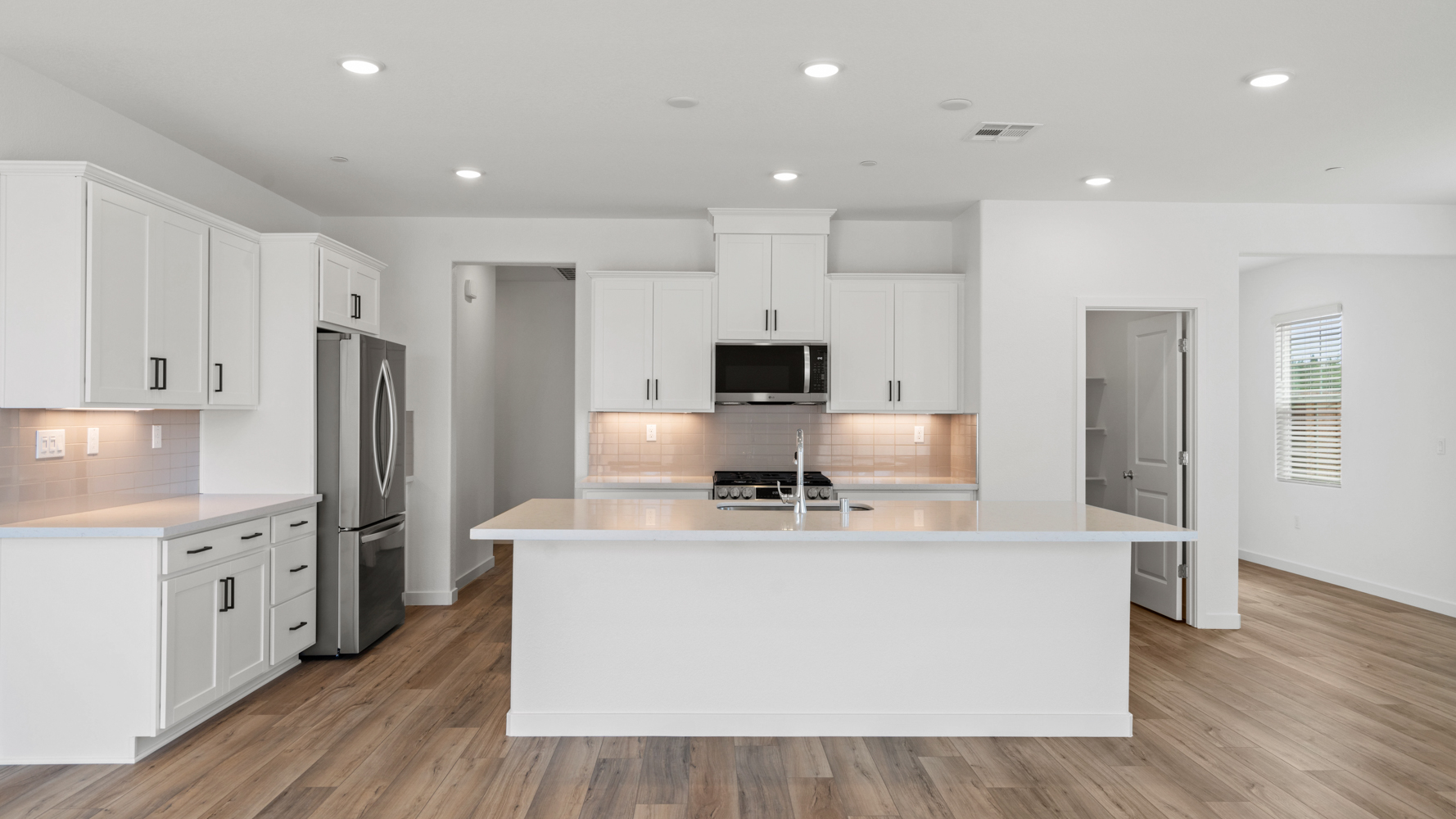 A kitchen with white cabinets.