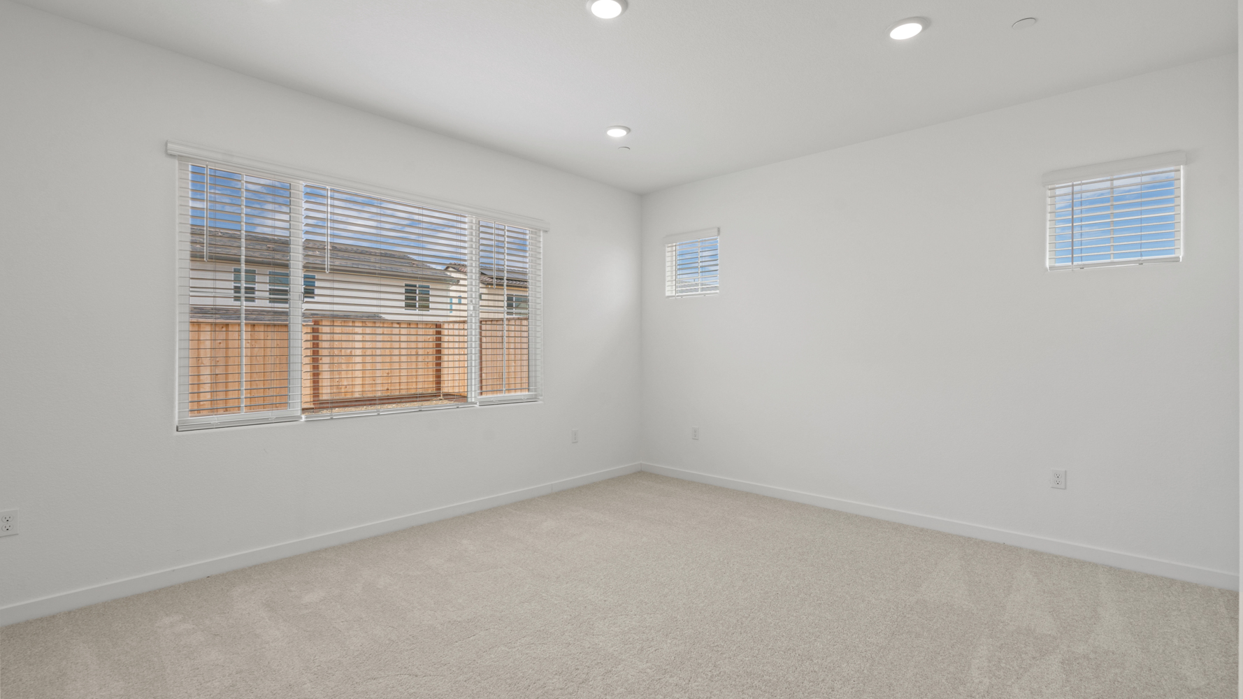 A room with a window and a white wall with a white floor.