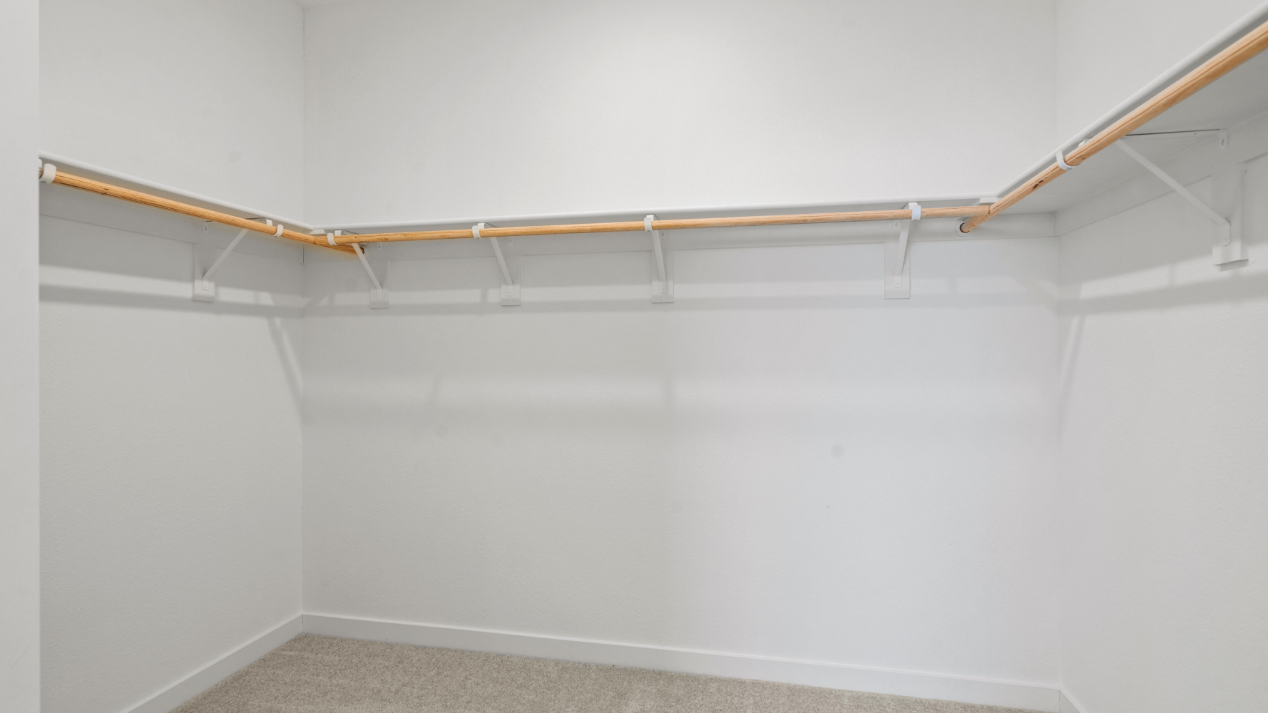 A white wall with a wooden pole.