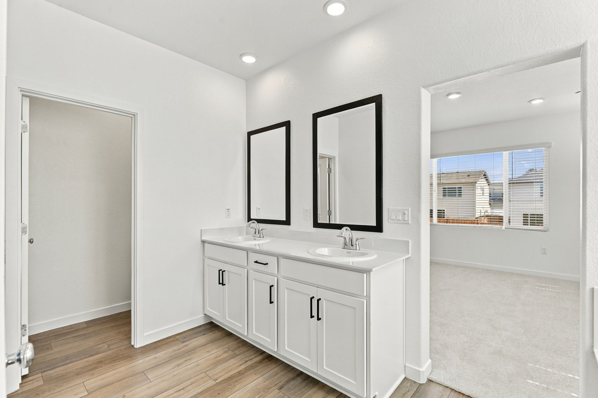 A bathroom with white cabinets.