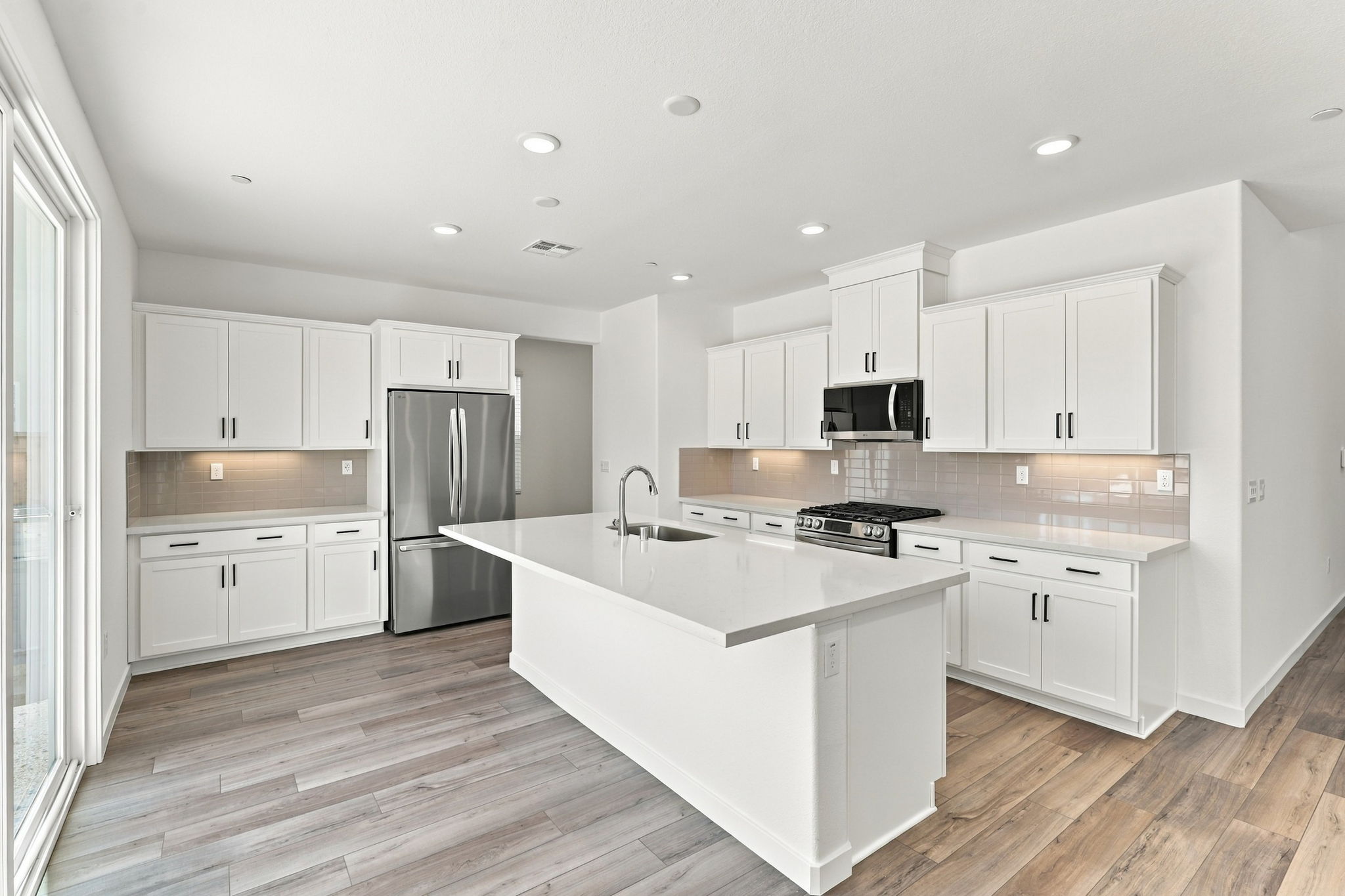 A kitchen with white cabinets.