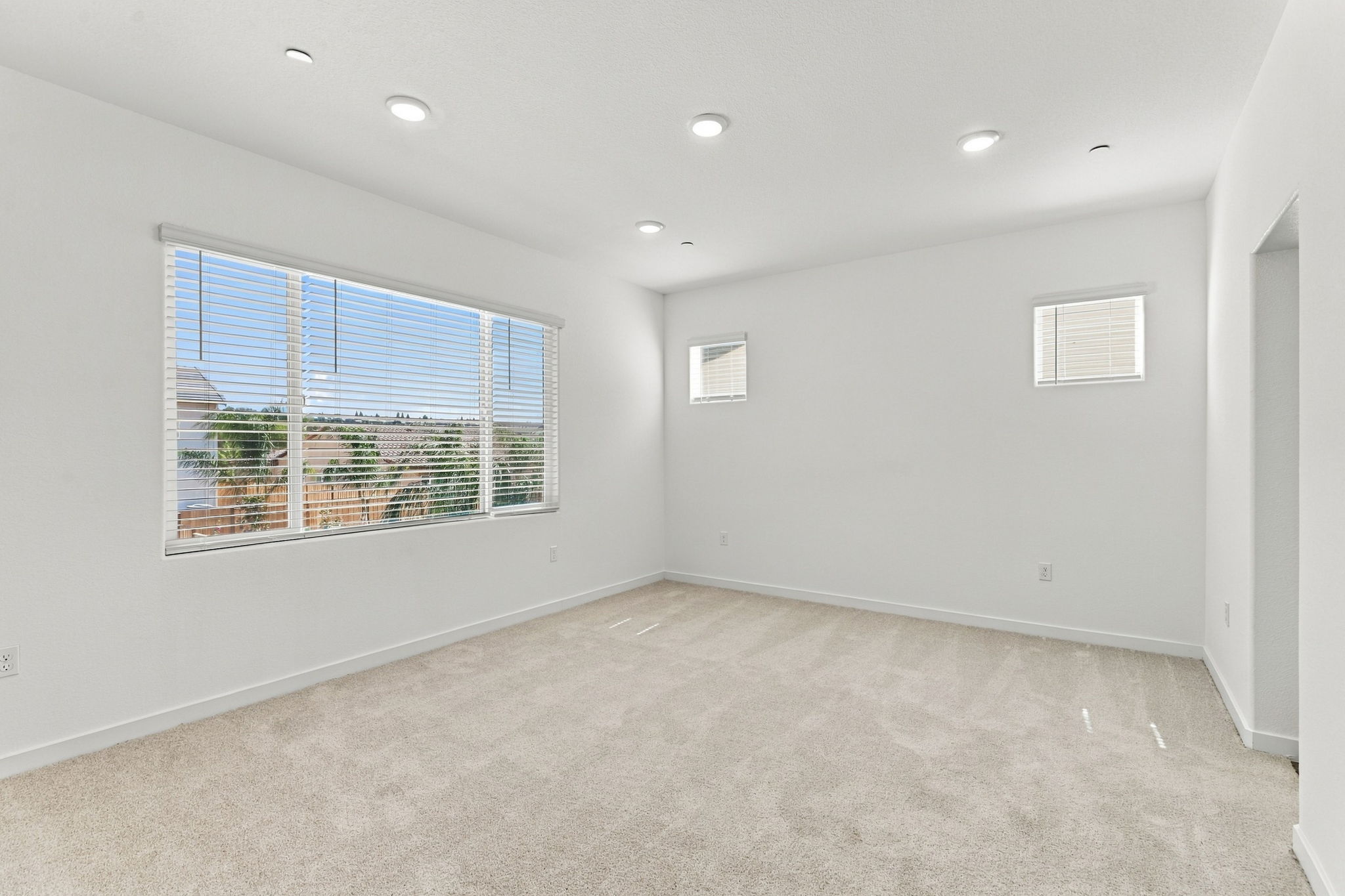 A room with a window and a white wall.