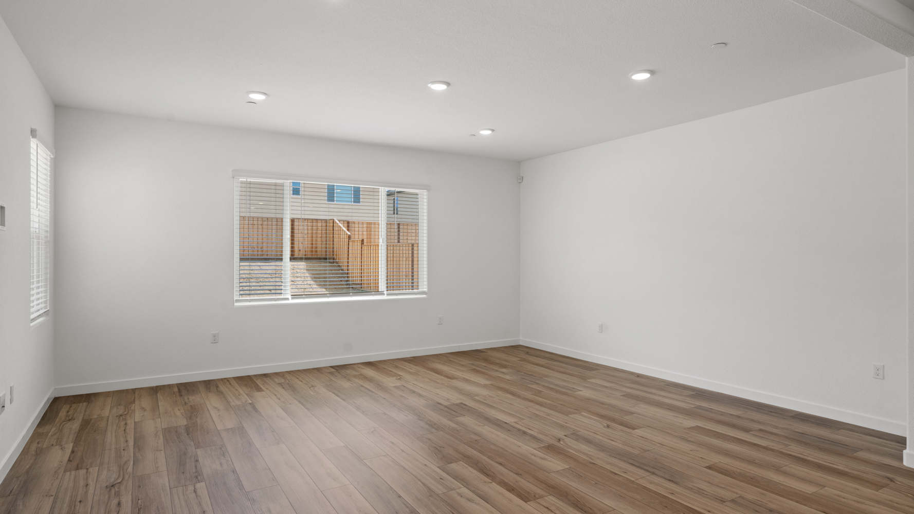 A room with a wood floor and a window.