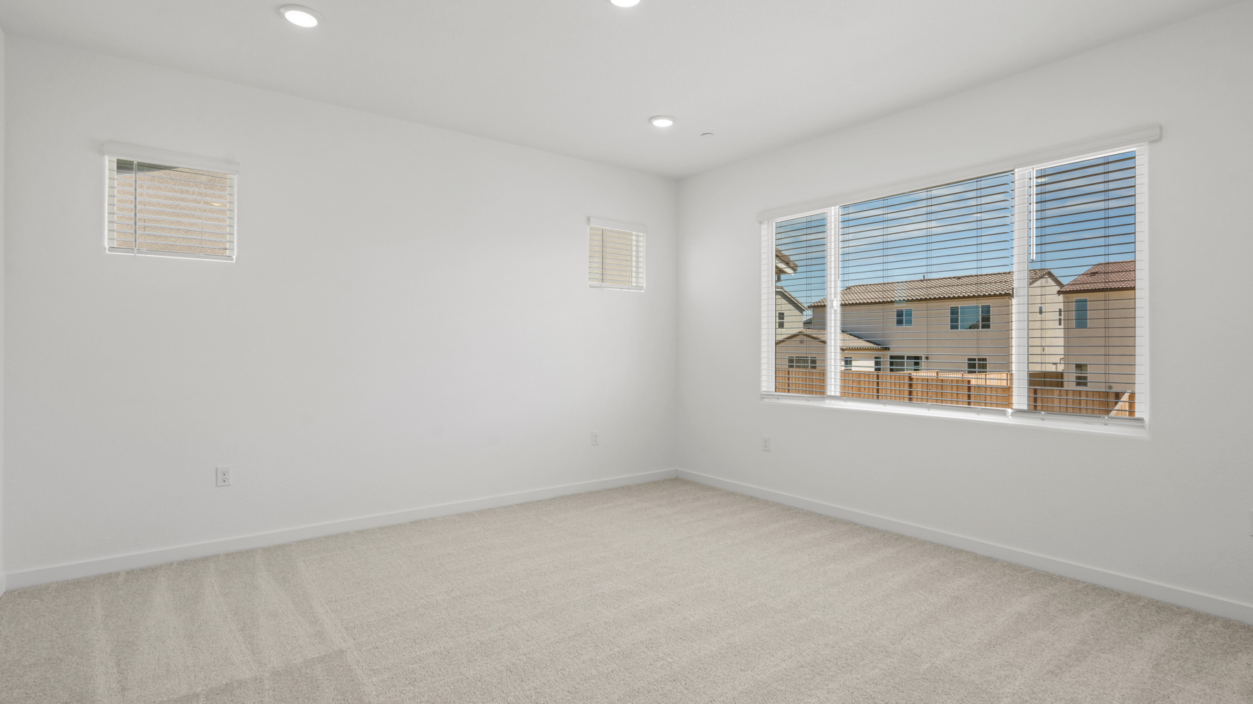 A room with a window and a white wall with a white floor.