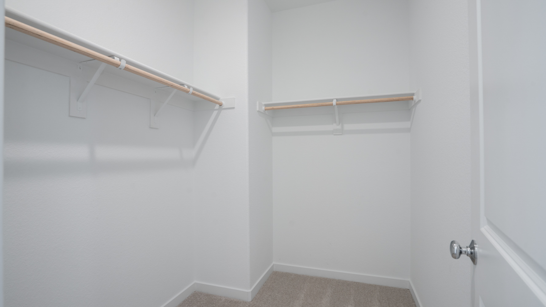 A white wall with a metal bar.