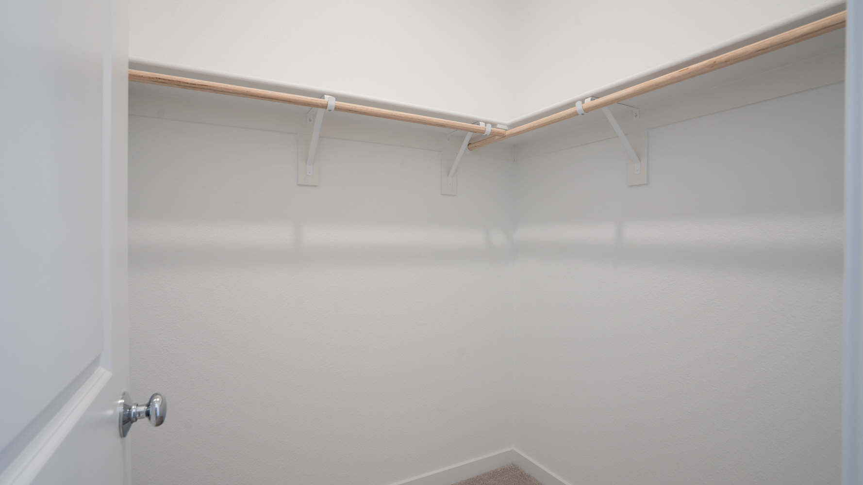 A white wall with a metal bar.