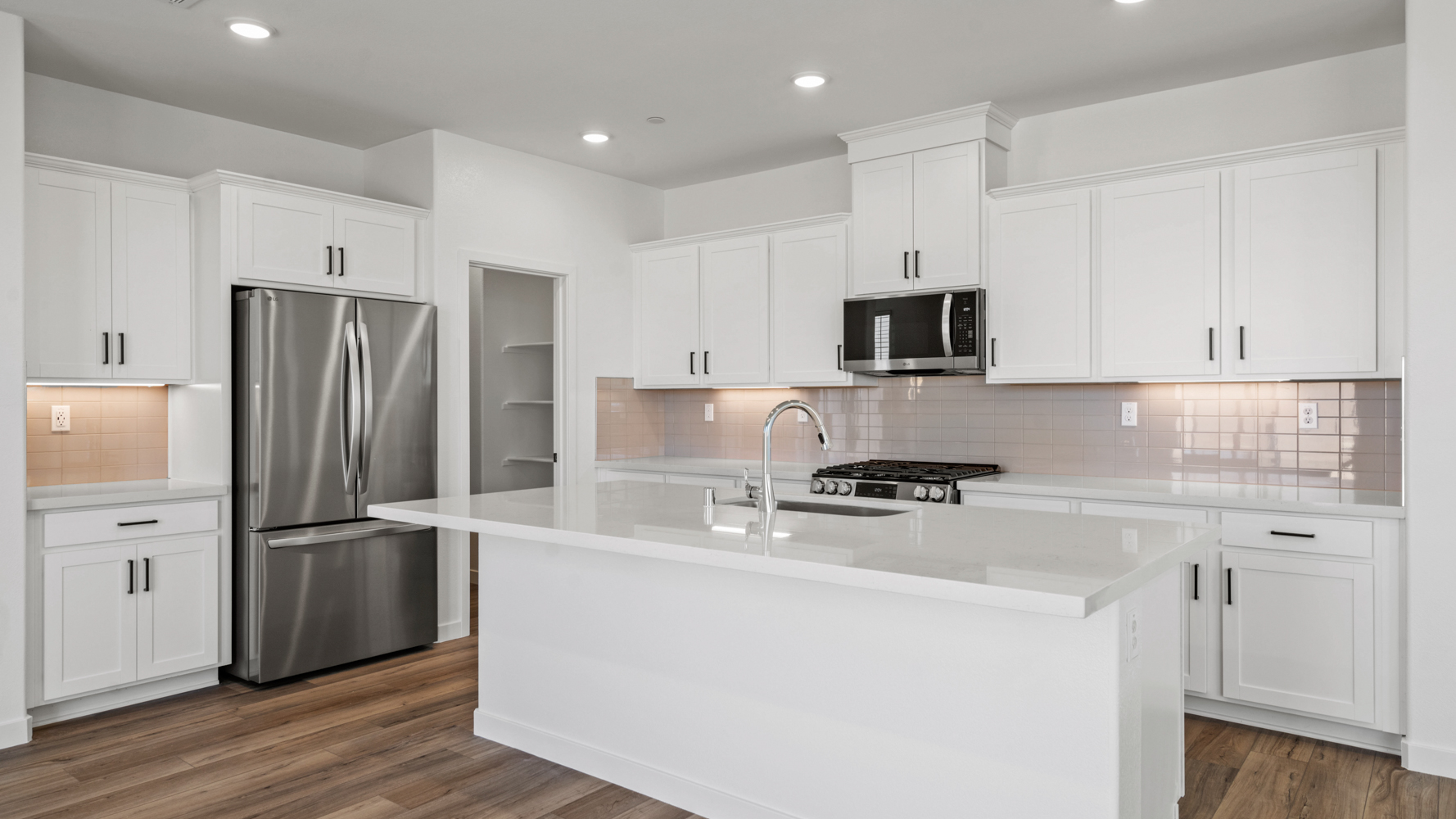 A kitchen with white cabinets.