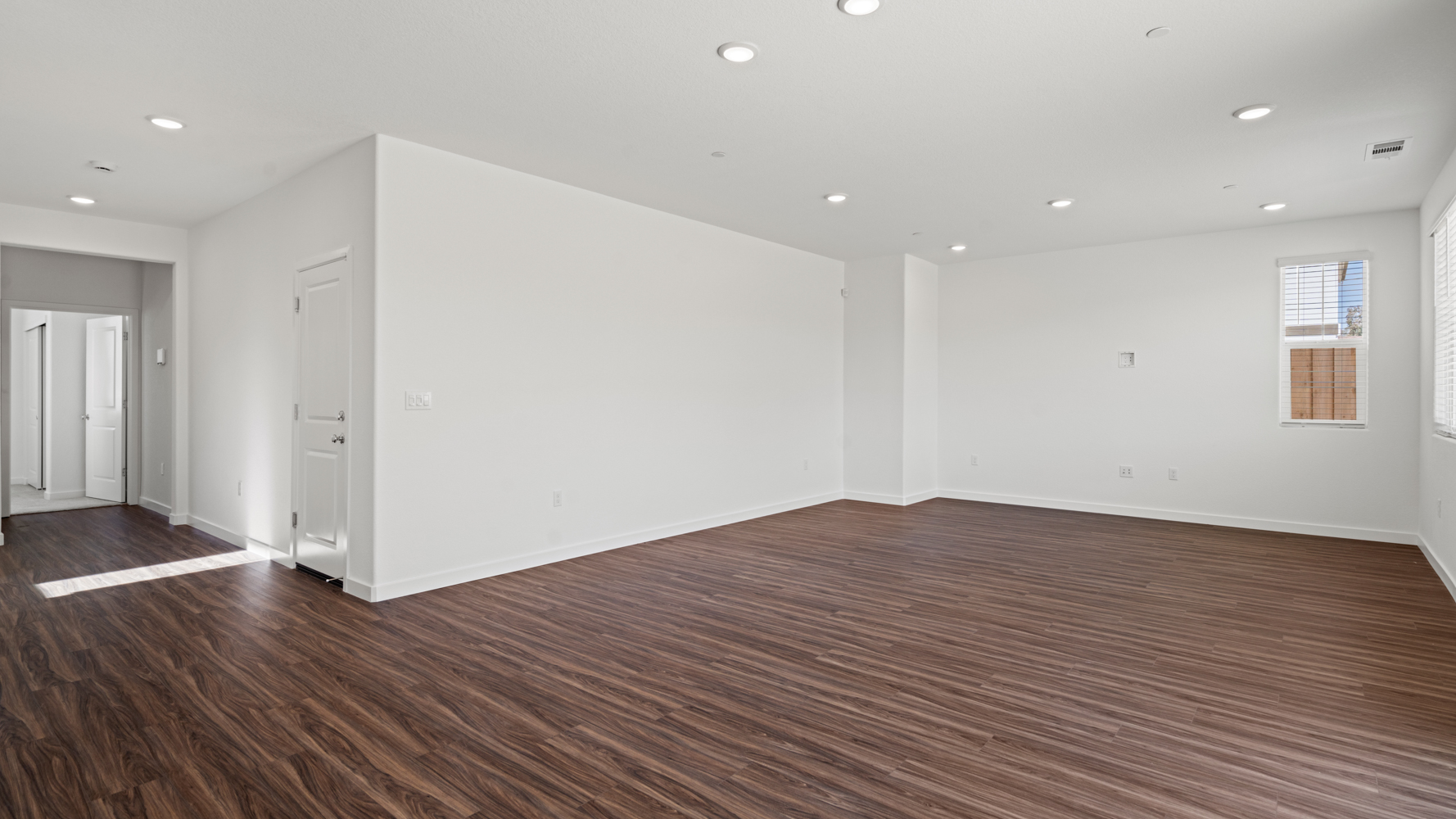 A room with white walls and wood floors.