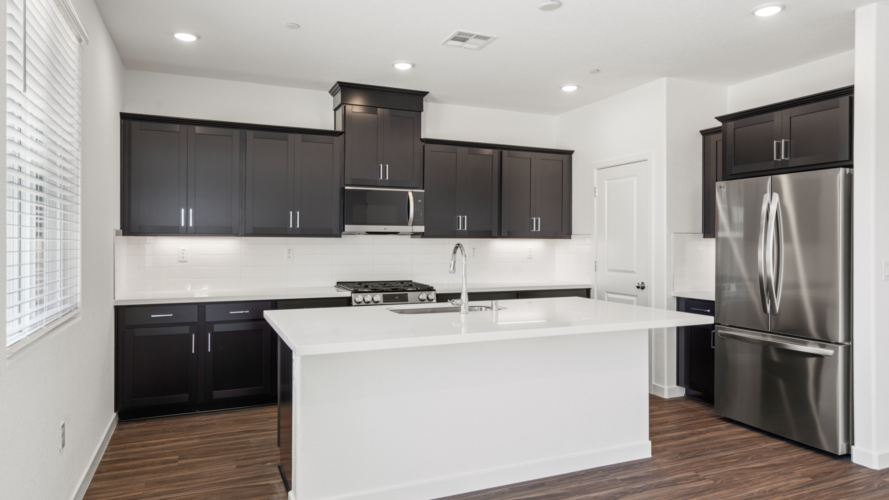 A kitchen with black cabinets.