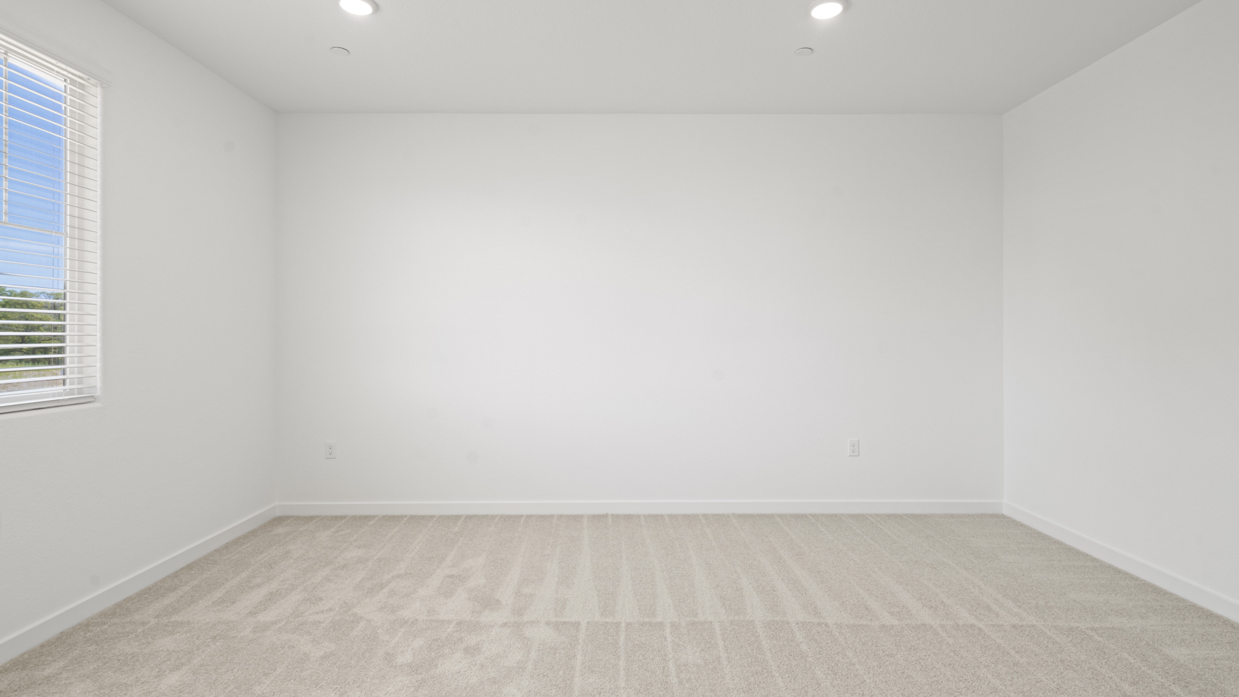 A room with a white wall and a window.