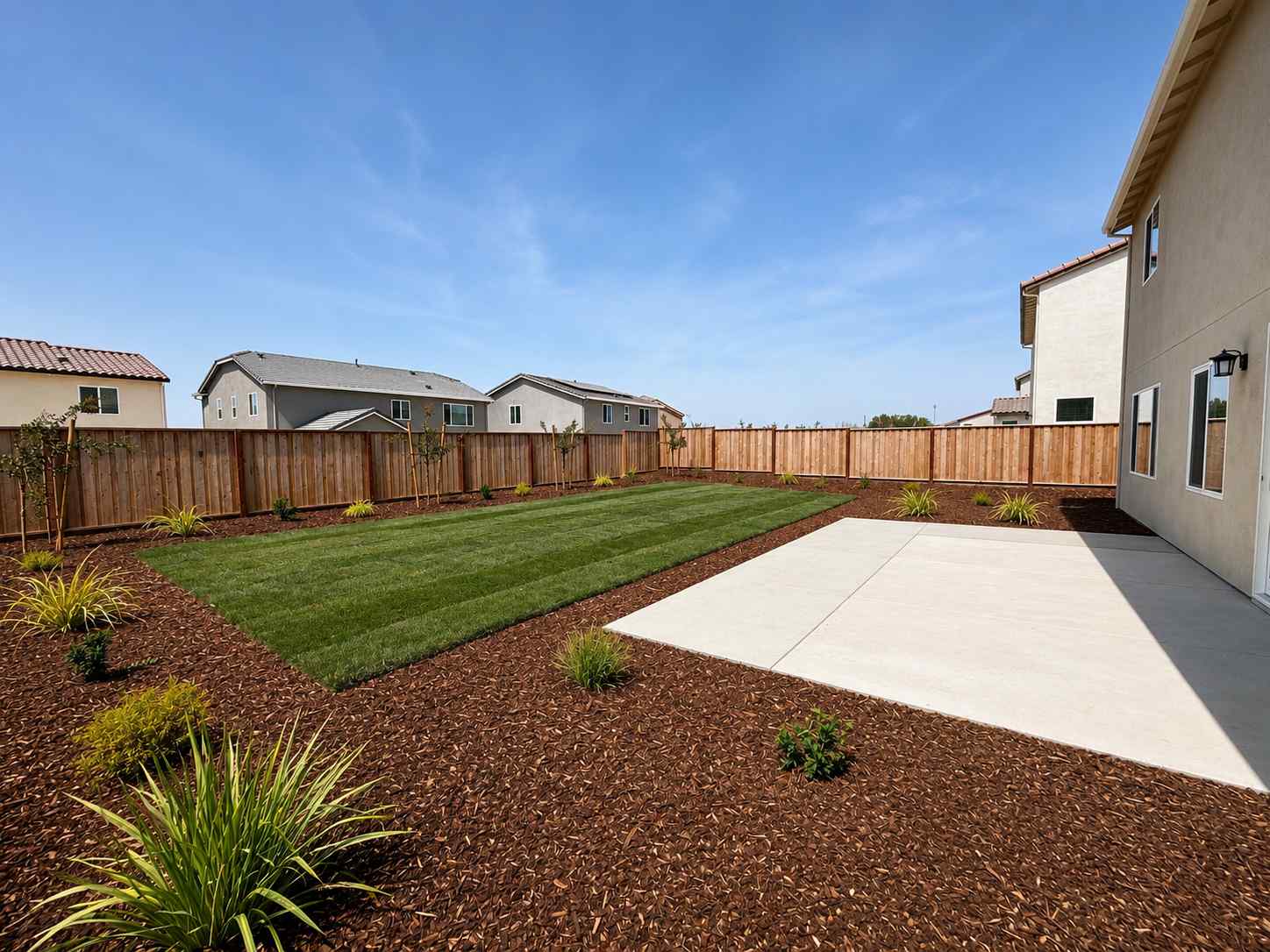 A backyard with a fence and a brick path.