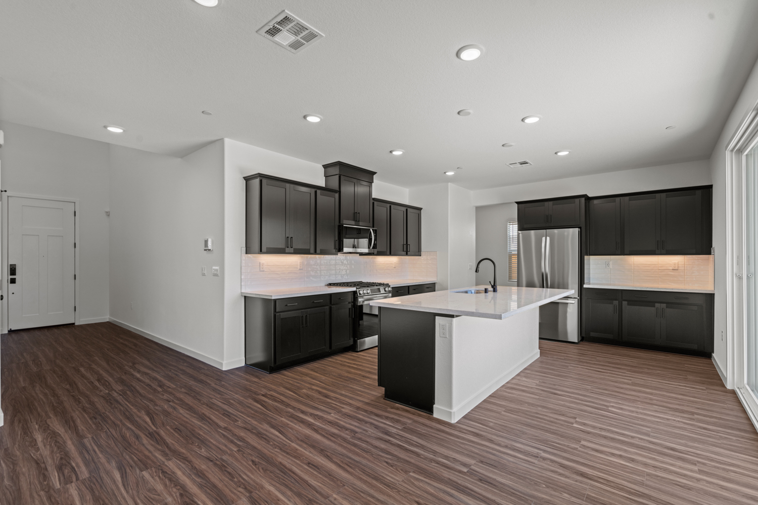A kitchen with black cabinets.