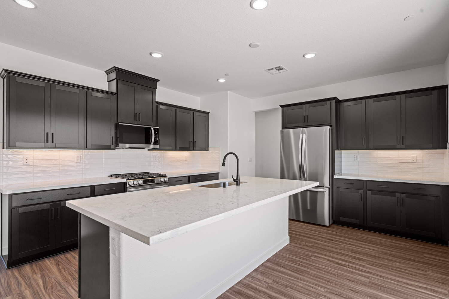 A kitchen with black cabinets.
