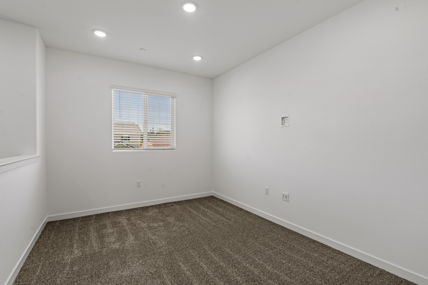 A room with a window and a carpet.