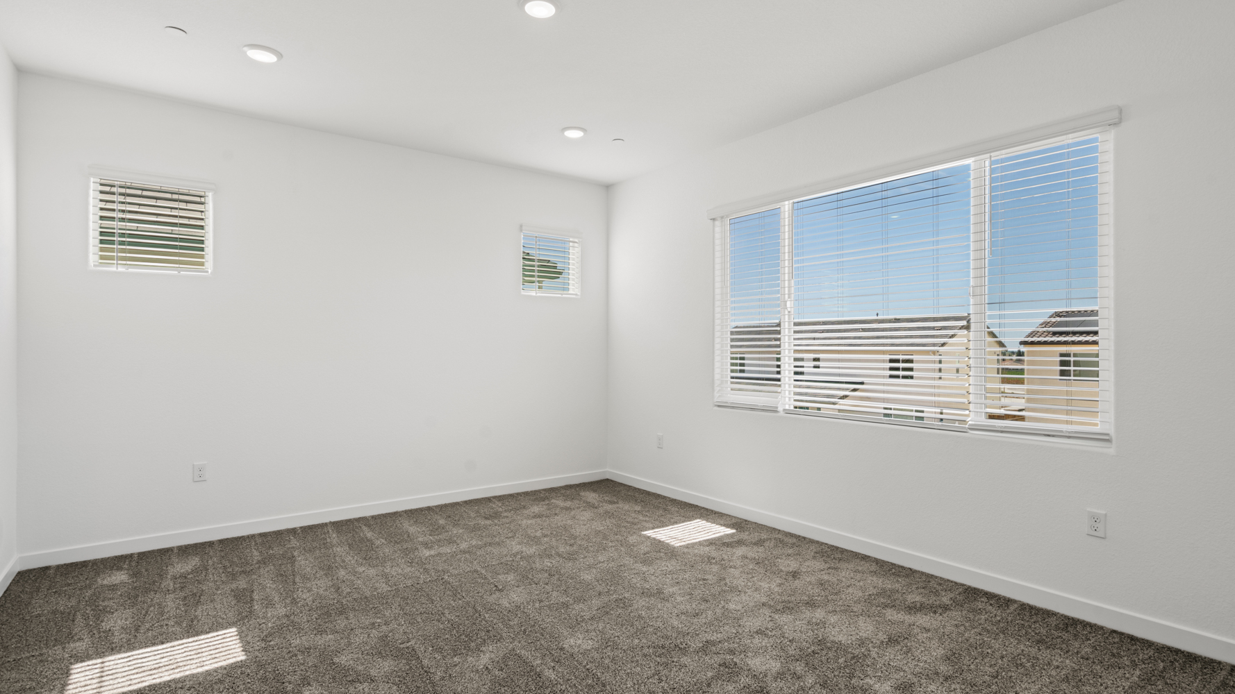 A room with a window and a rug.