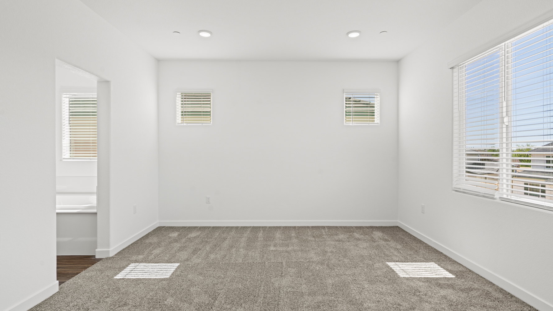 A room with a white wall and windows.