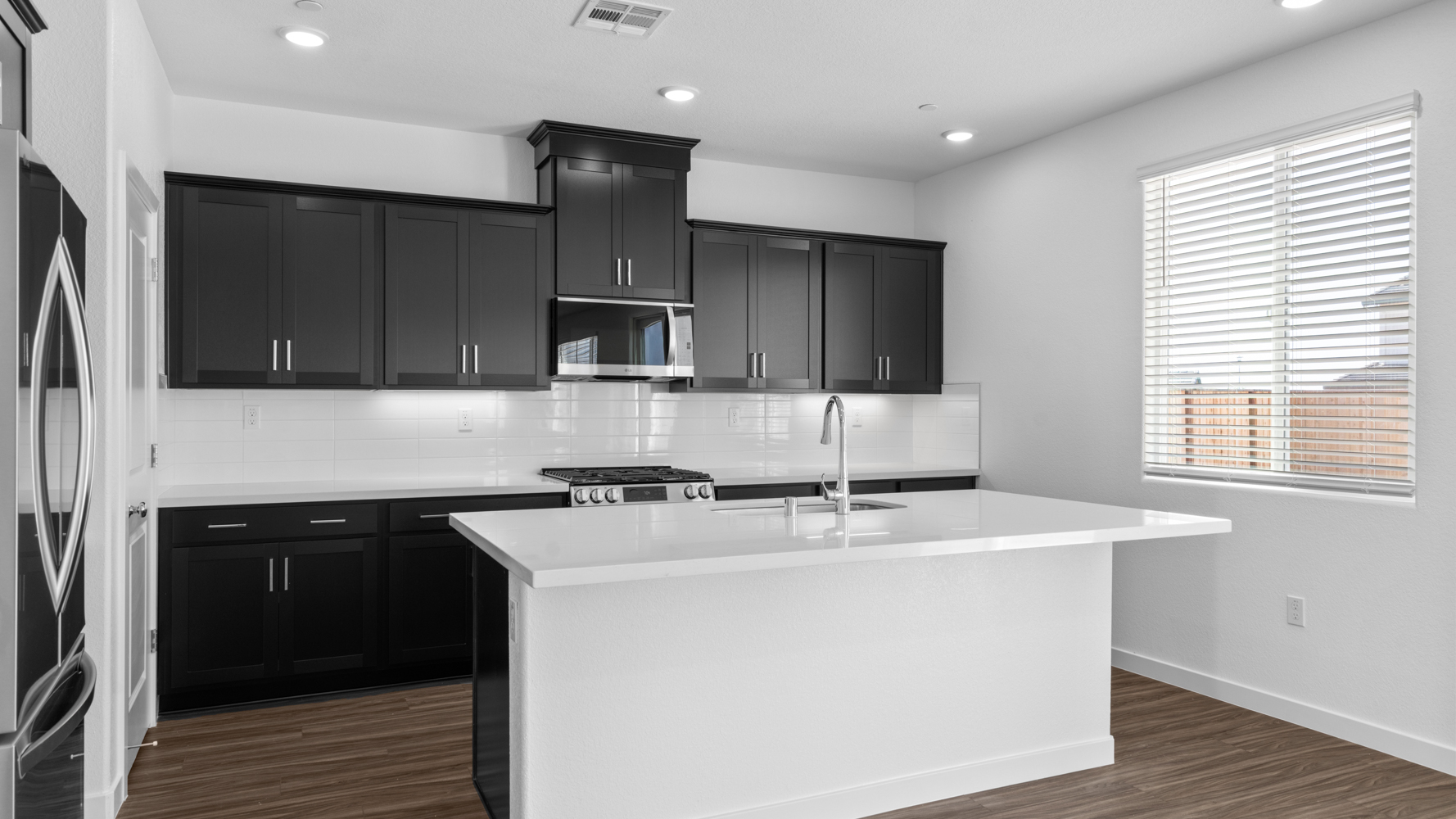 A kitchen with black cabinets.