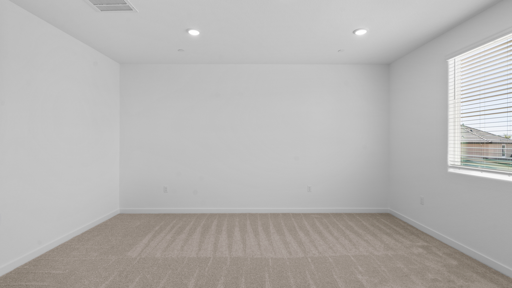 A room with a white wall and a wood floor.