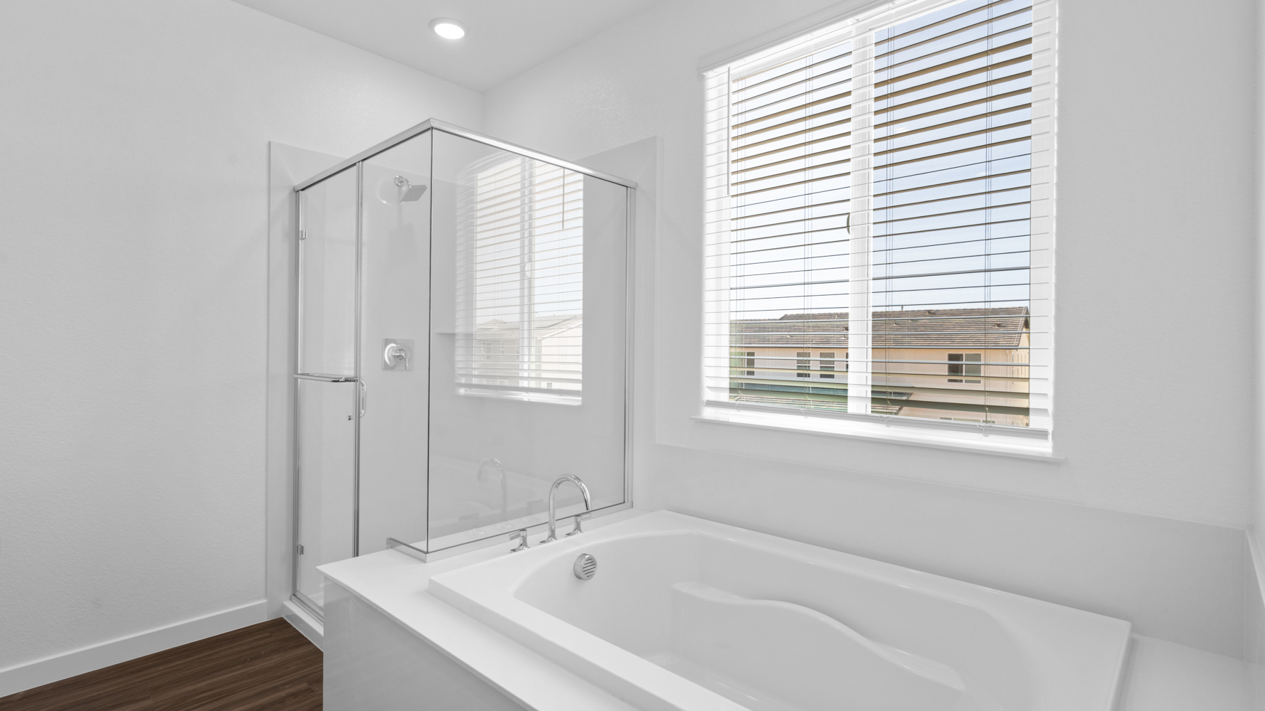 A bathtub and a window in a bathroom.