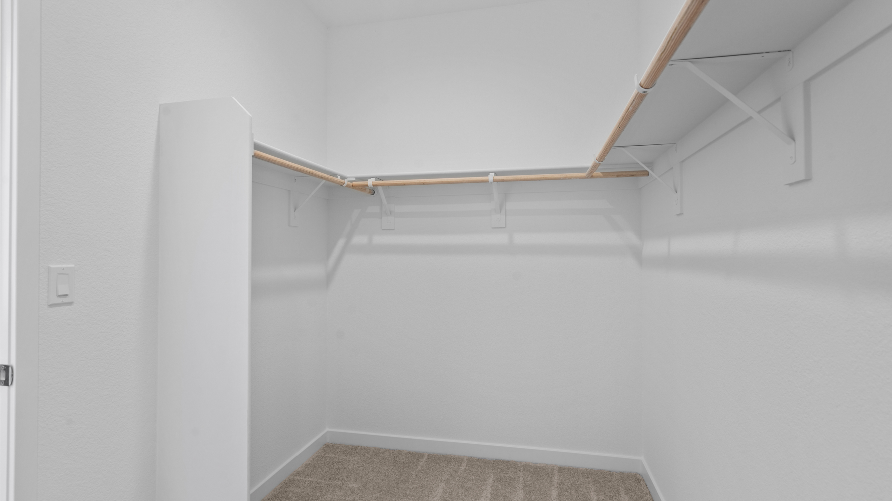 A white staircase with a wooden railing.