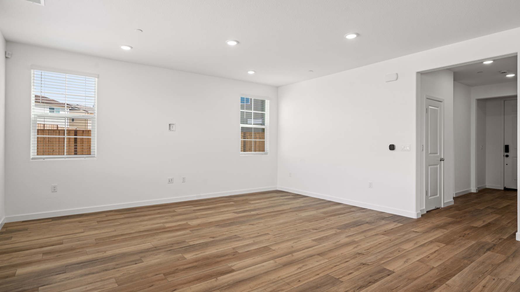 A room with a wood floor and white walls.