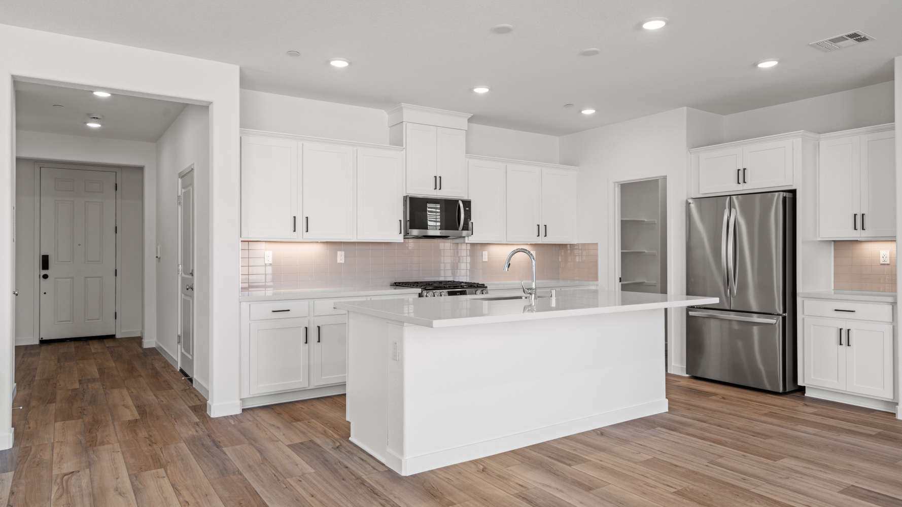 A kitchen with white cabinets.