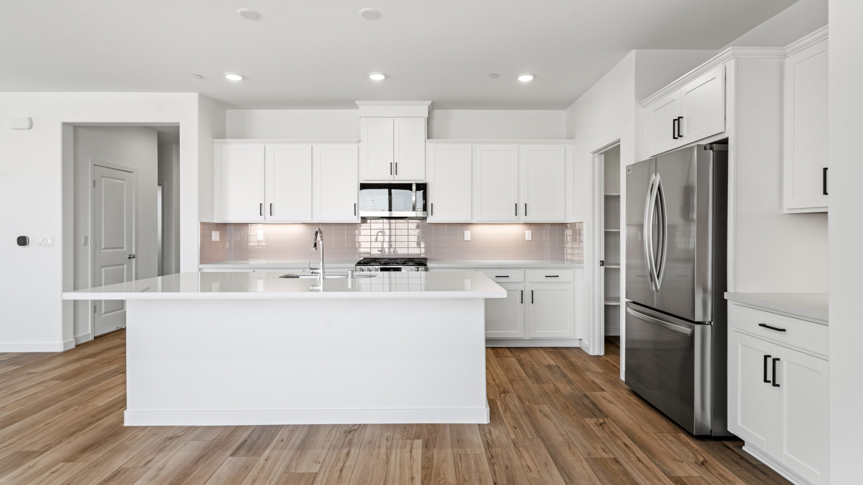 A kitchen with white cabinets.