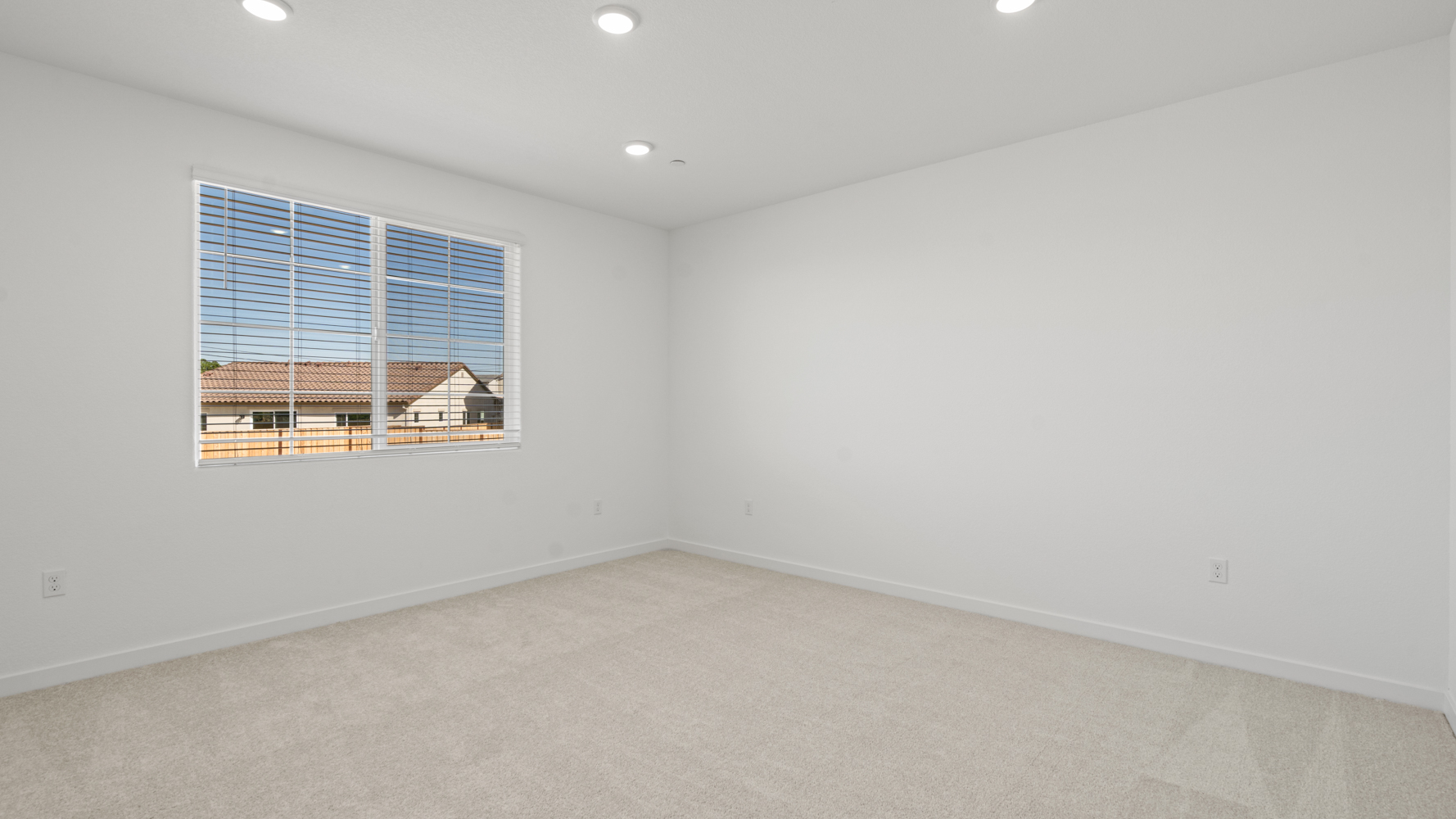A room with a window and a white wall with a window.