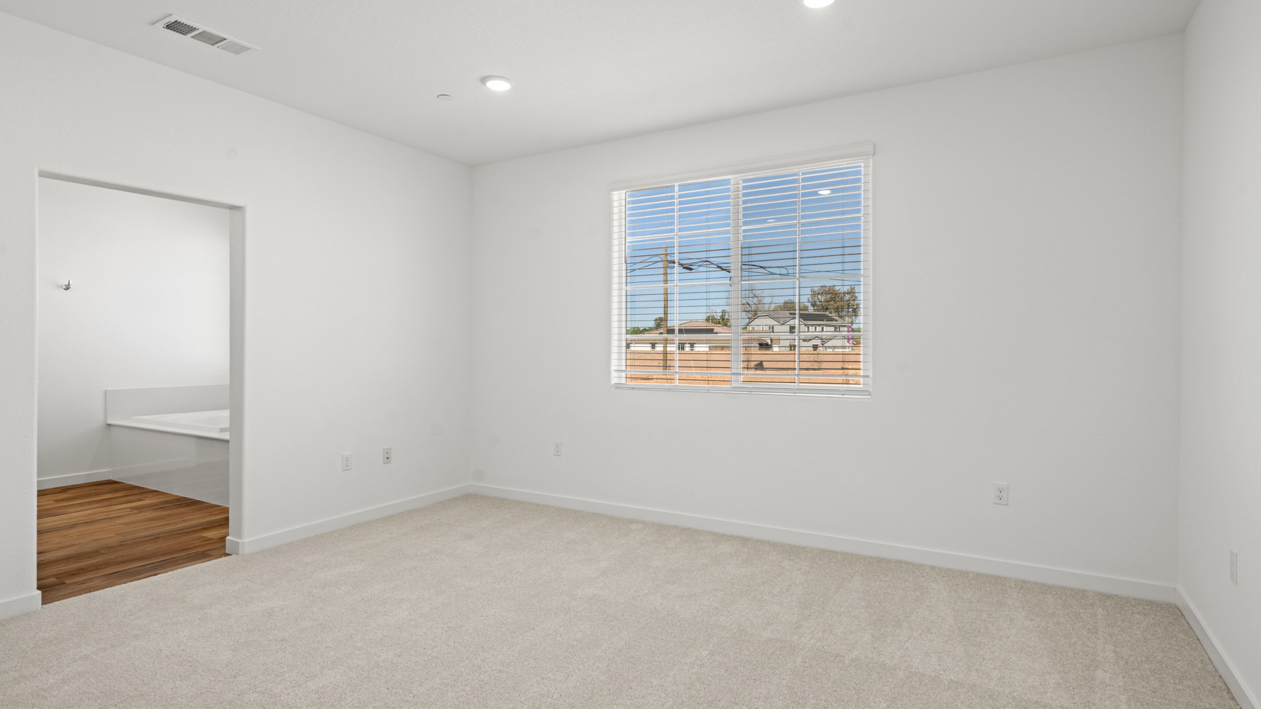 A room with a window and a wood floor.