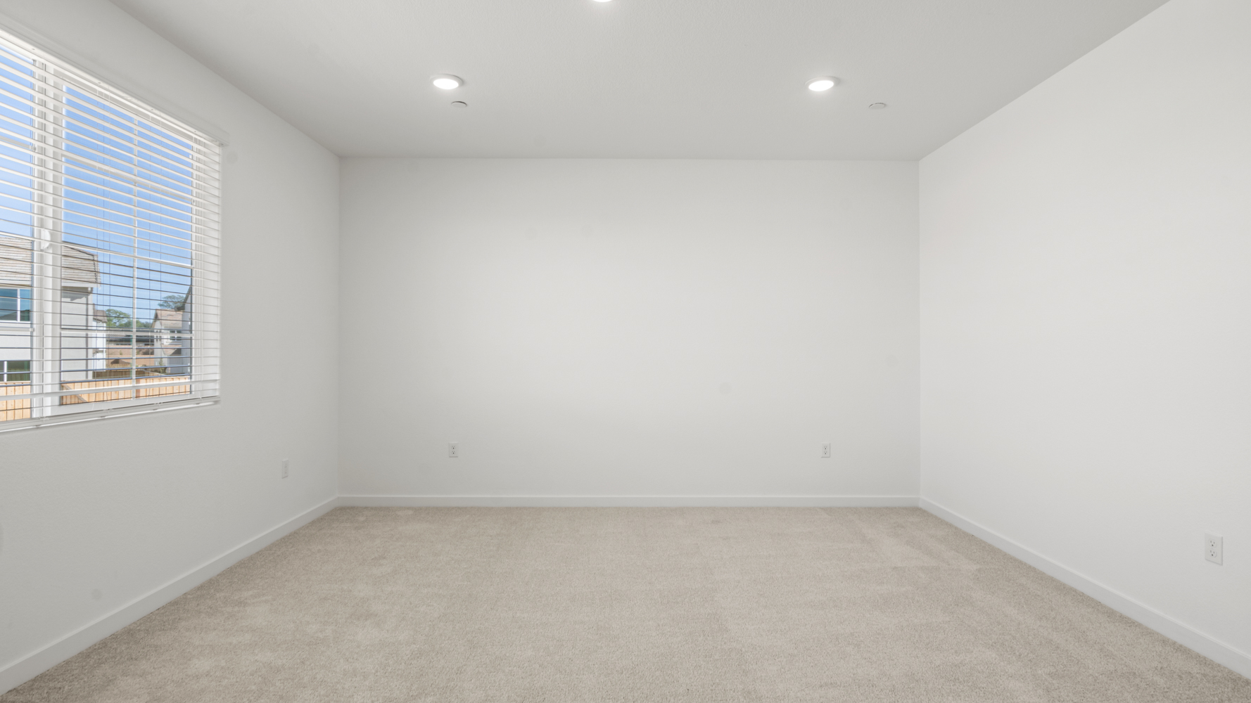 A room with a white wall and windows.