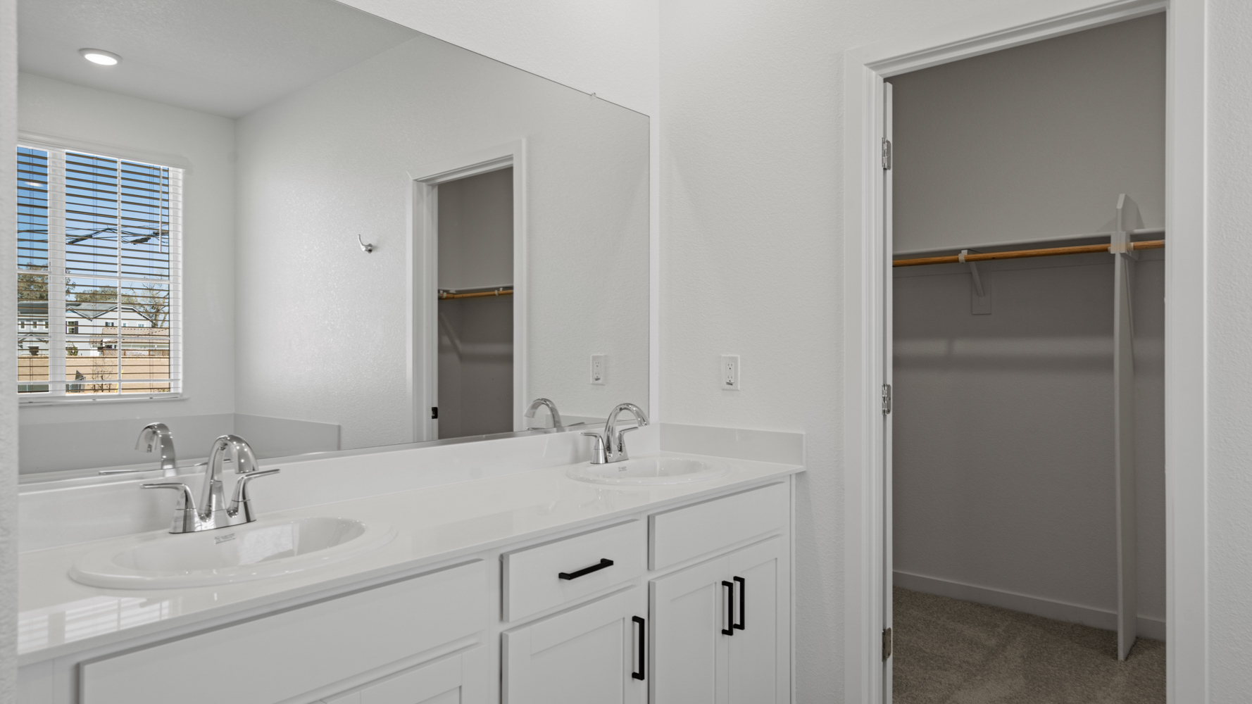 A bathroom with white cabinets.