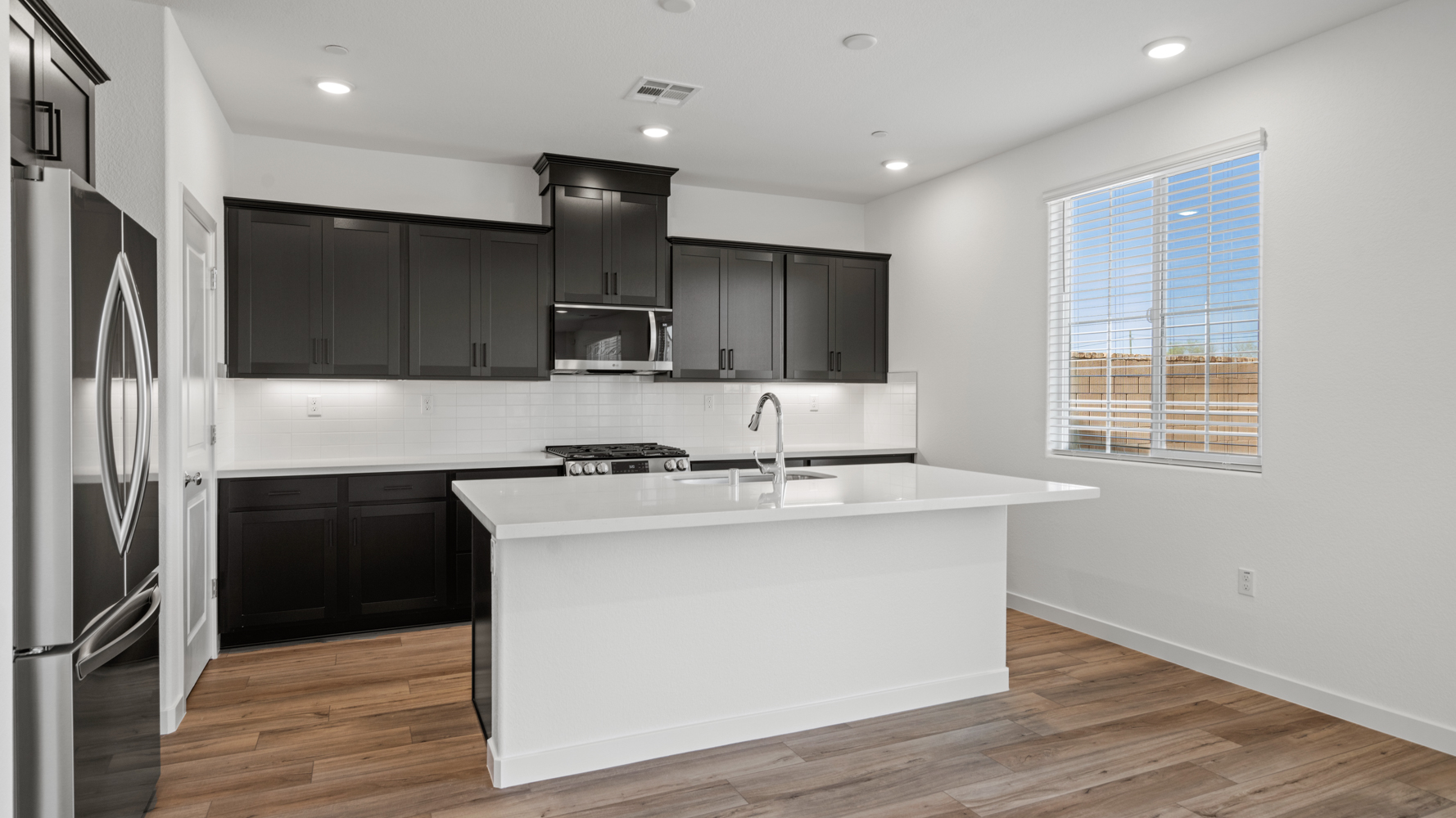 A kitchen with black cabinets.