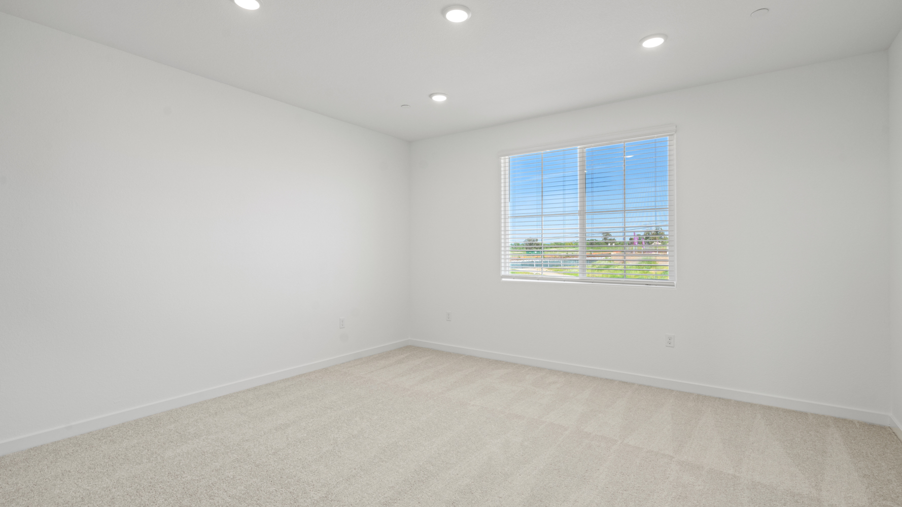 A room with a window and a white wall.