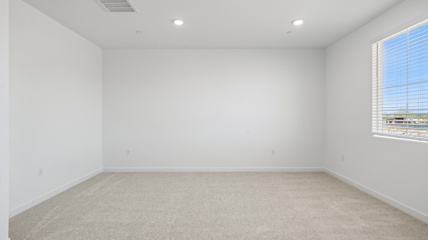 A room with a white wall and a window.