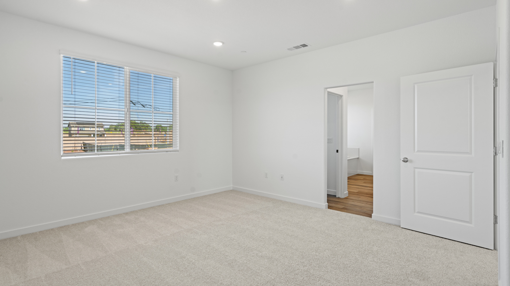 A room with white walls and a window.