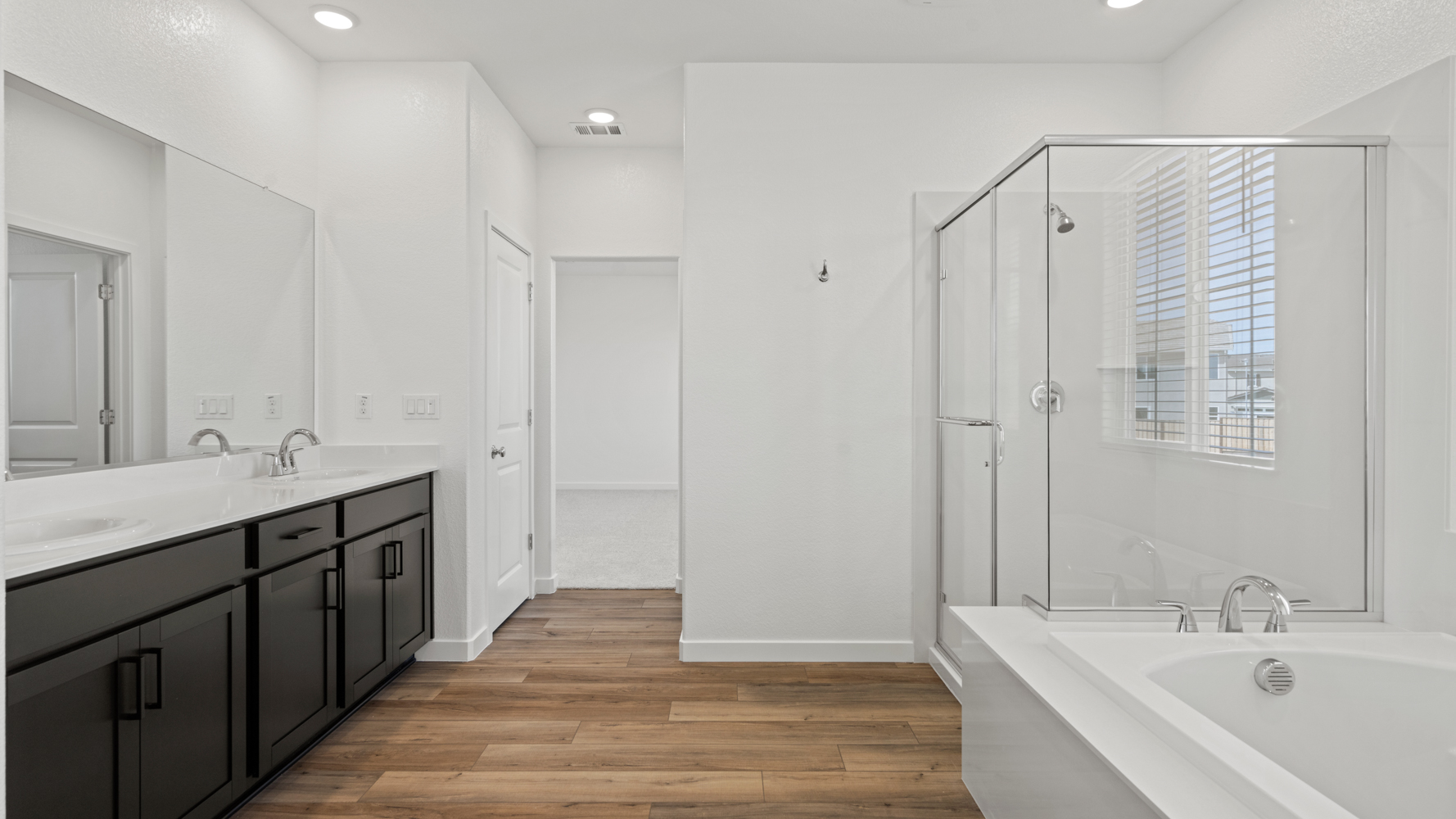 A bathroom with a tub sink and cabinets.