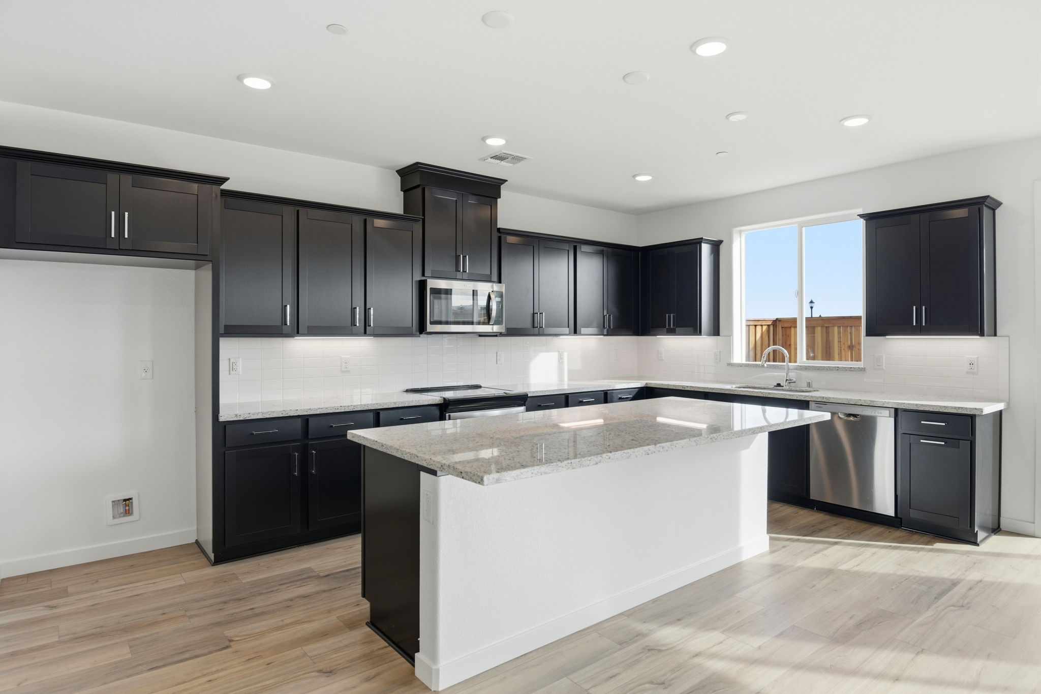 A kitchen with black cabinets.