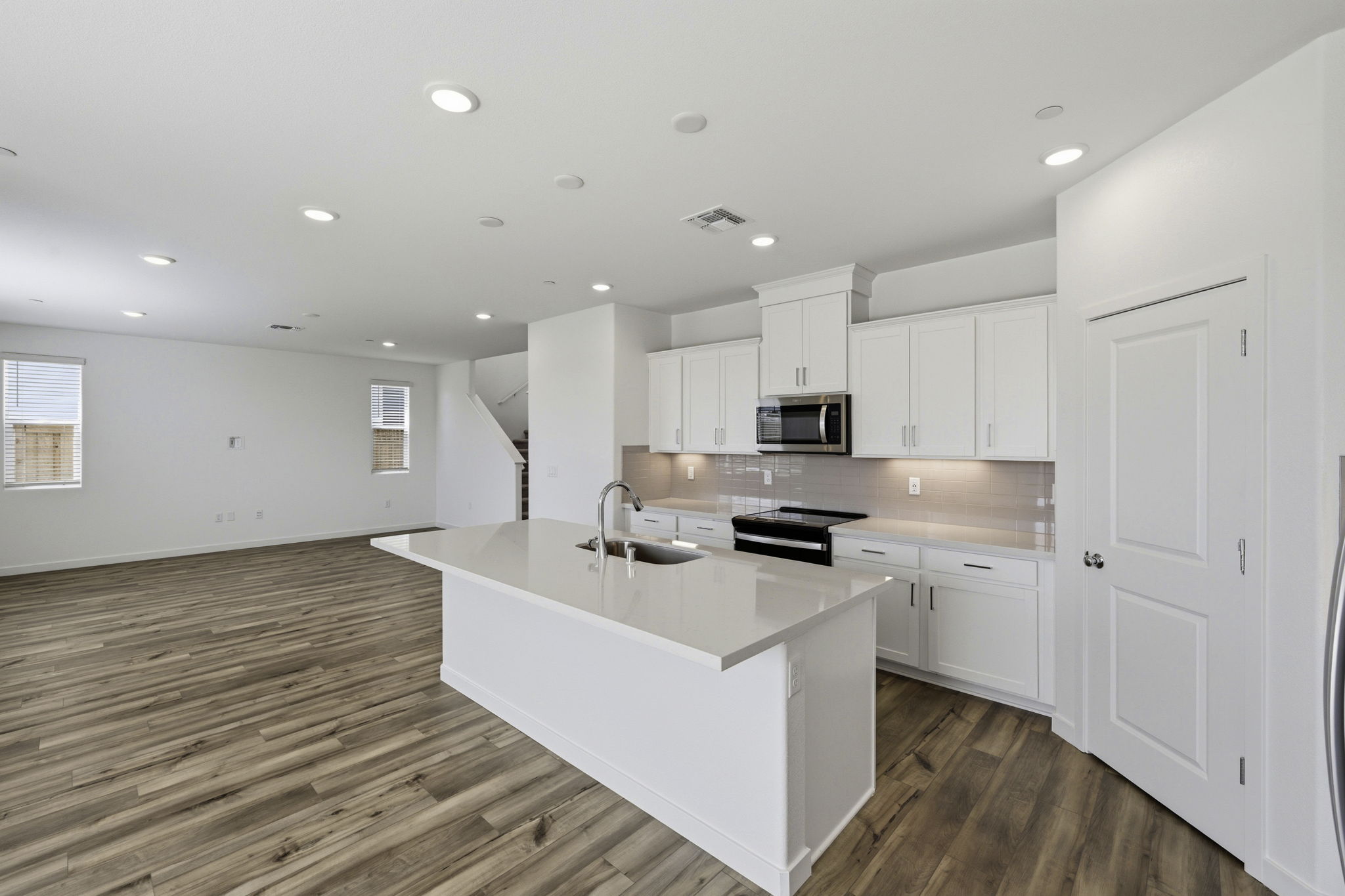 A kitchen with white cabinets.
