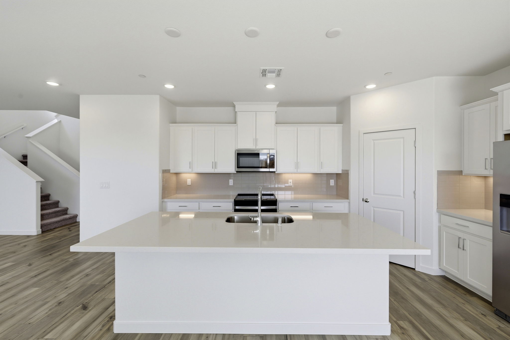 A kitchen with white cabinets.