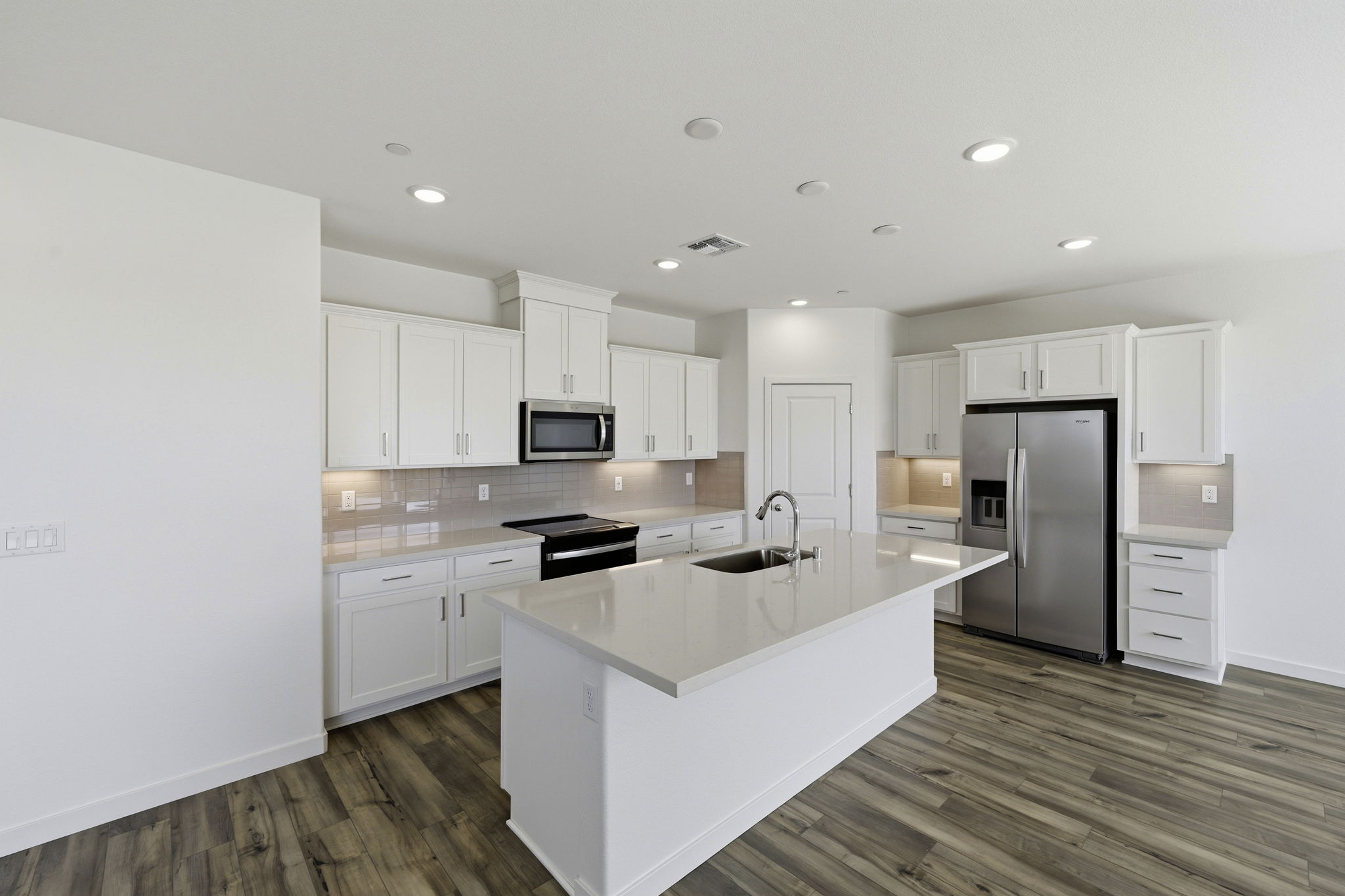A kitchen with white cabinets.