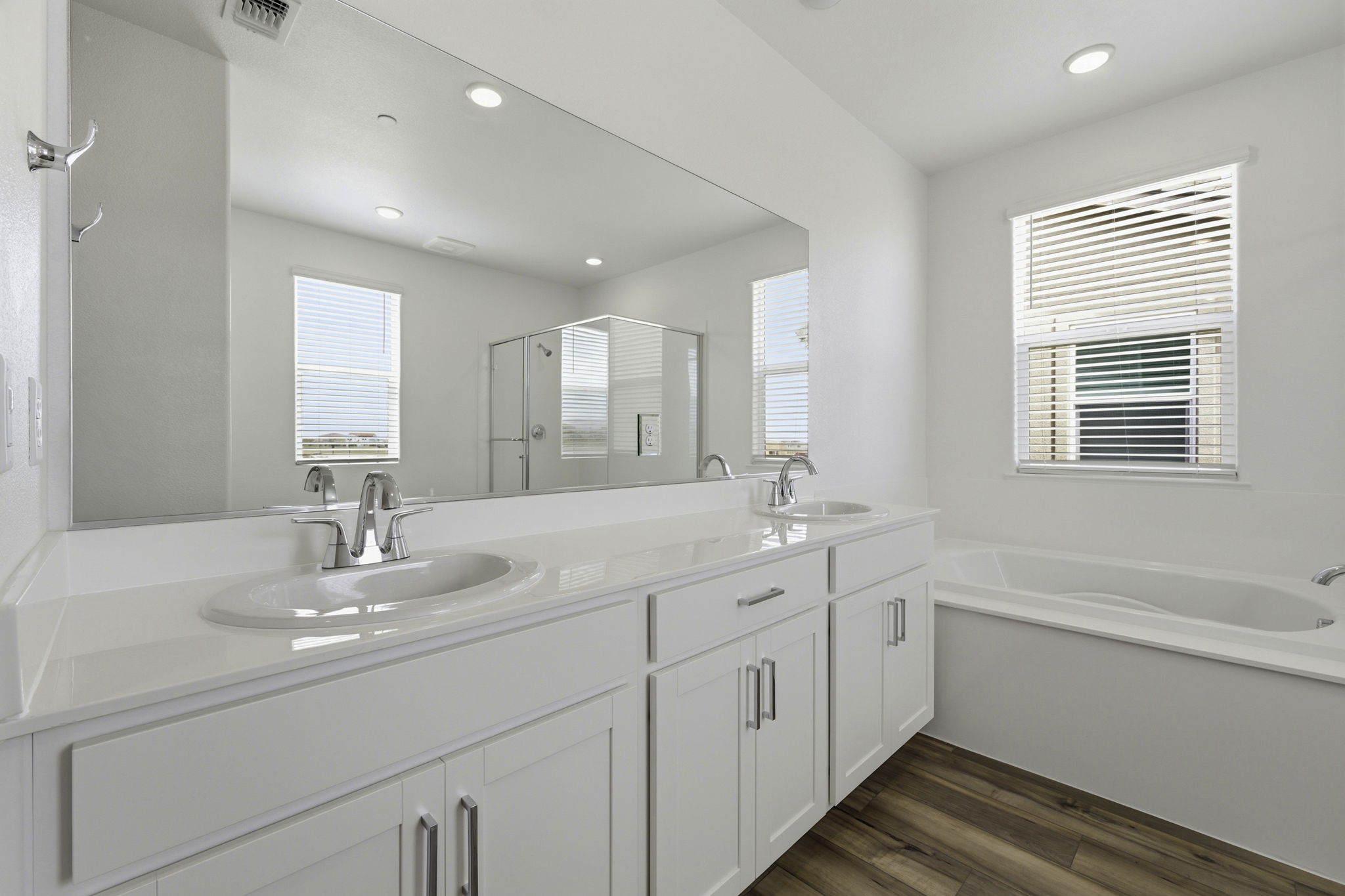 A bathroom with a tub sink and mirror.