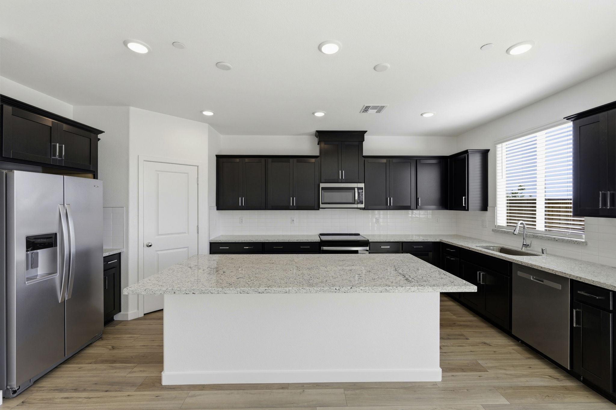 A kitchen with black cabinets.