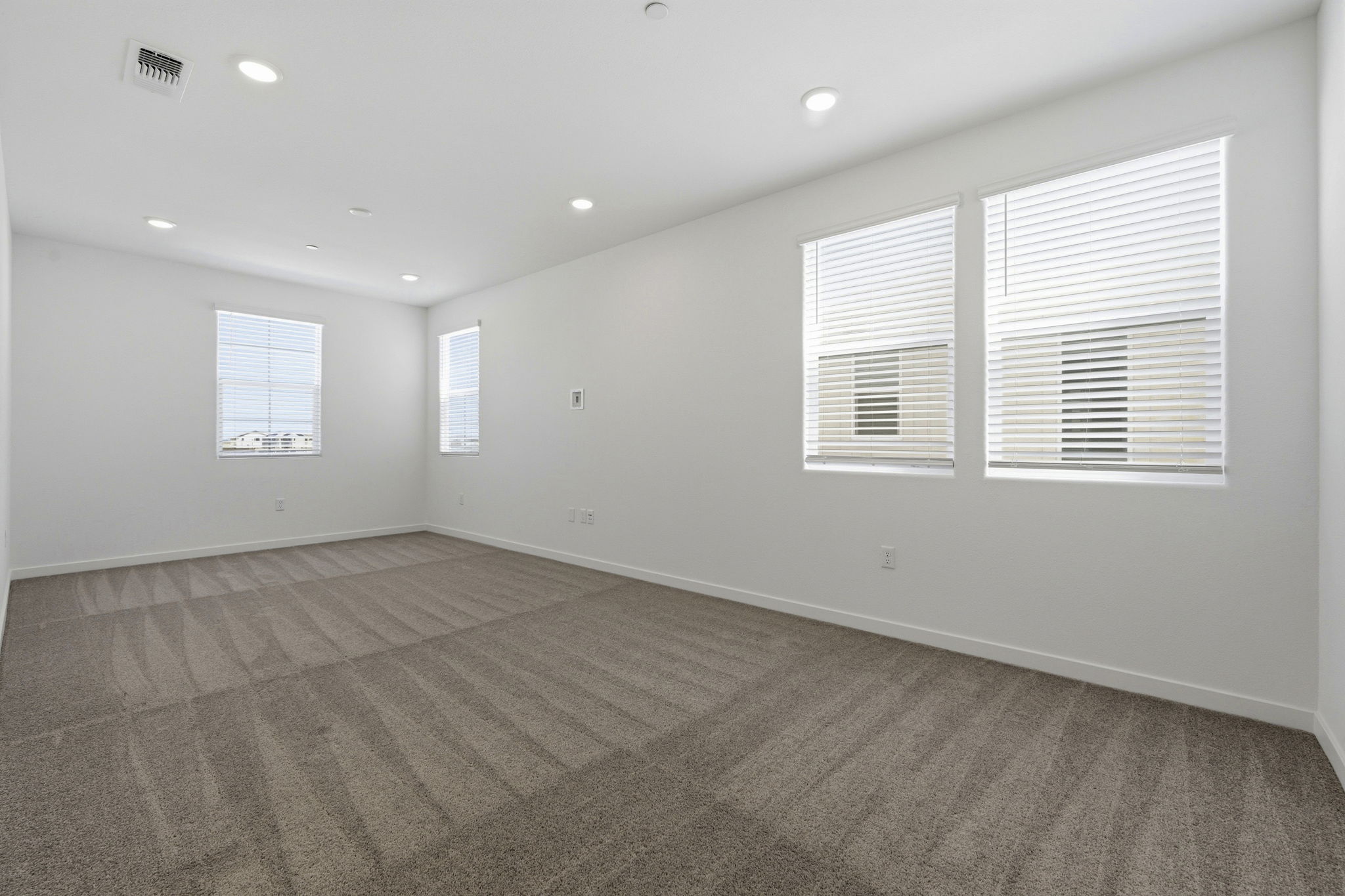 A room with a carpet and windows.