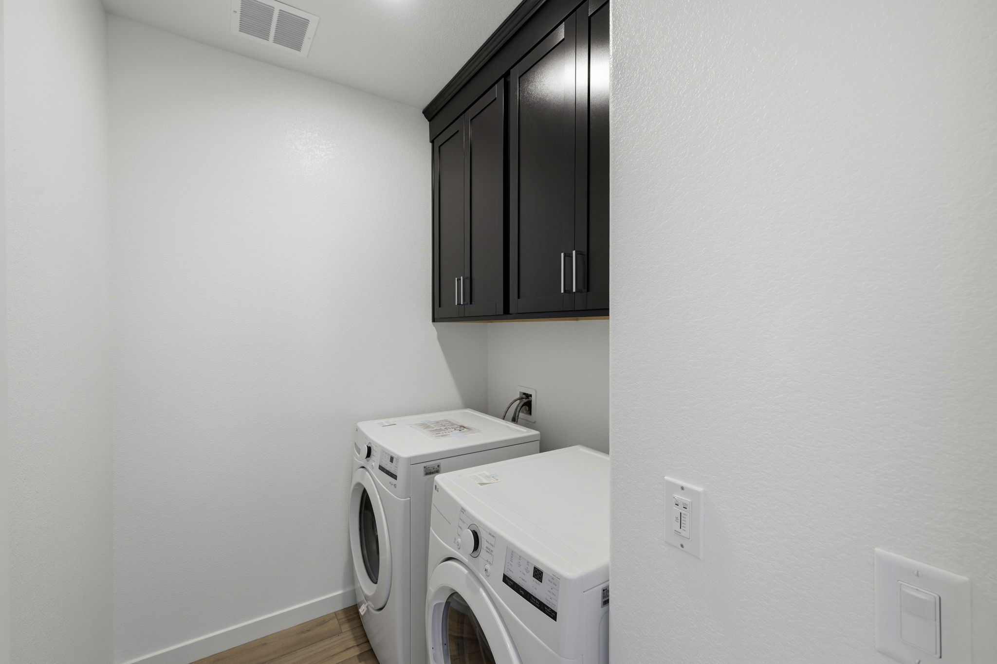 A room with a washing machine and a dryer.