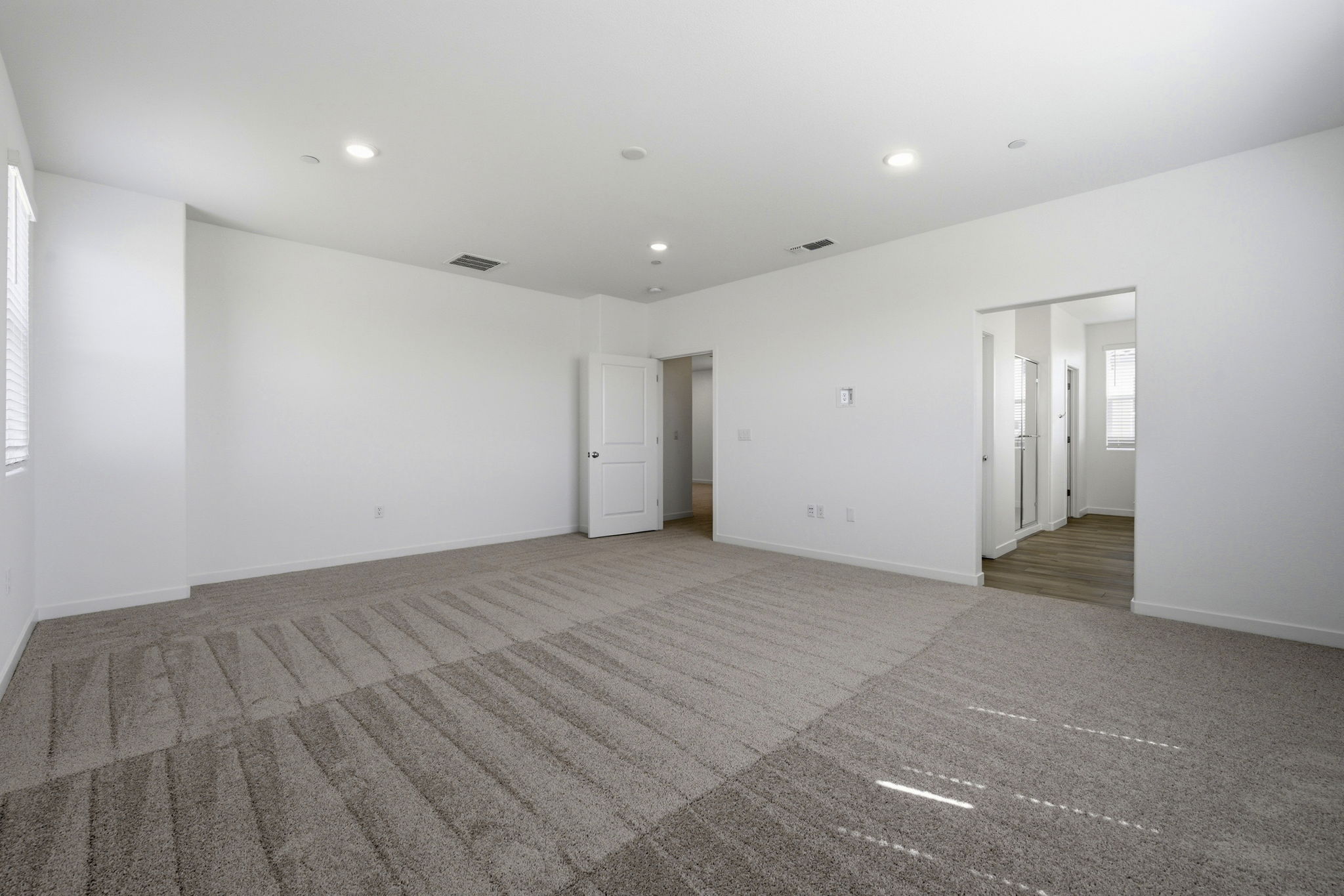 A long hallway with white doors.
