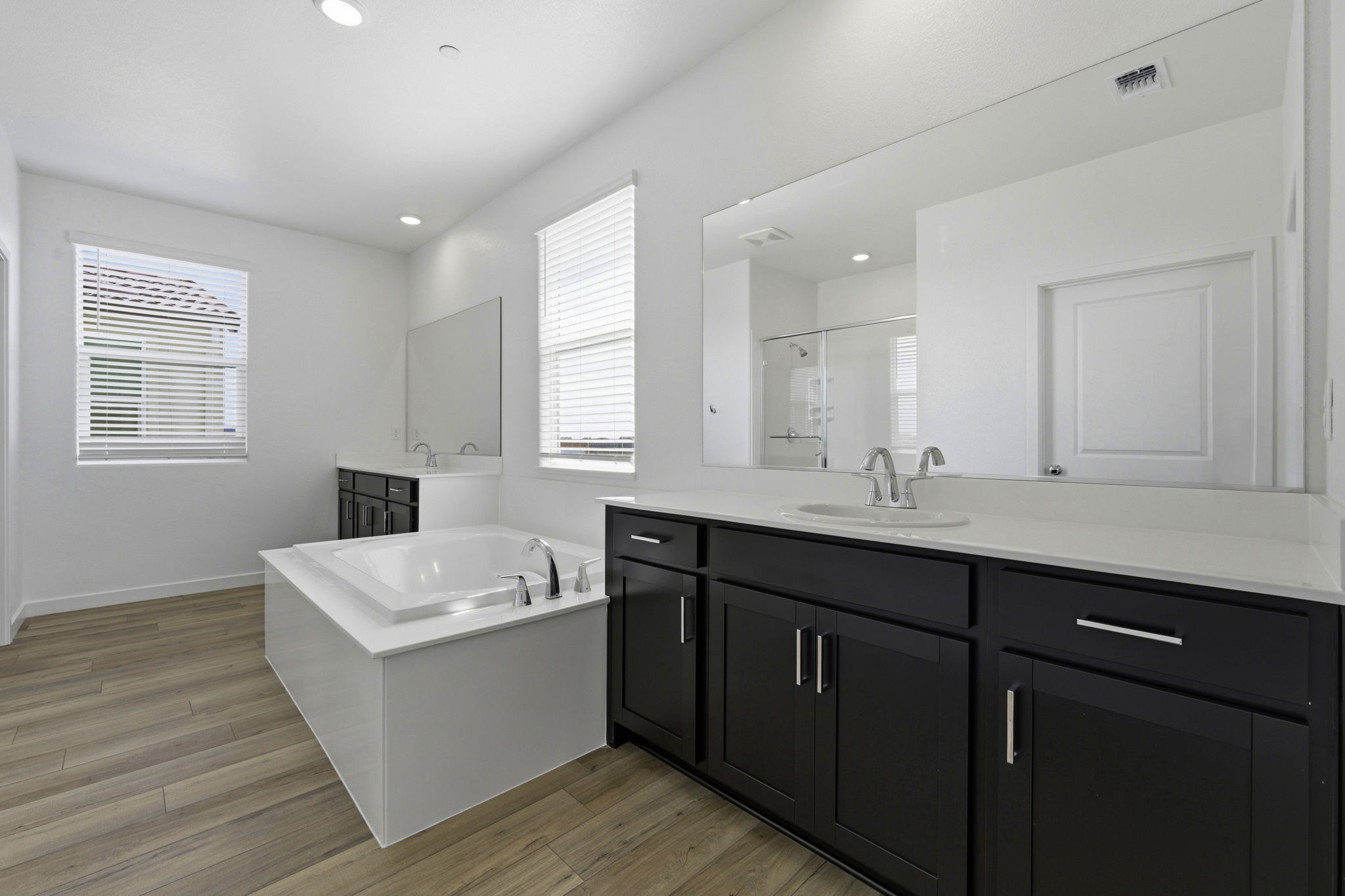 A bathroom with a tub sink and cabinets.